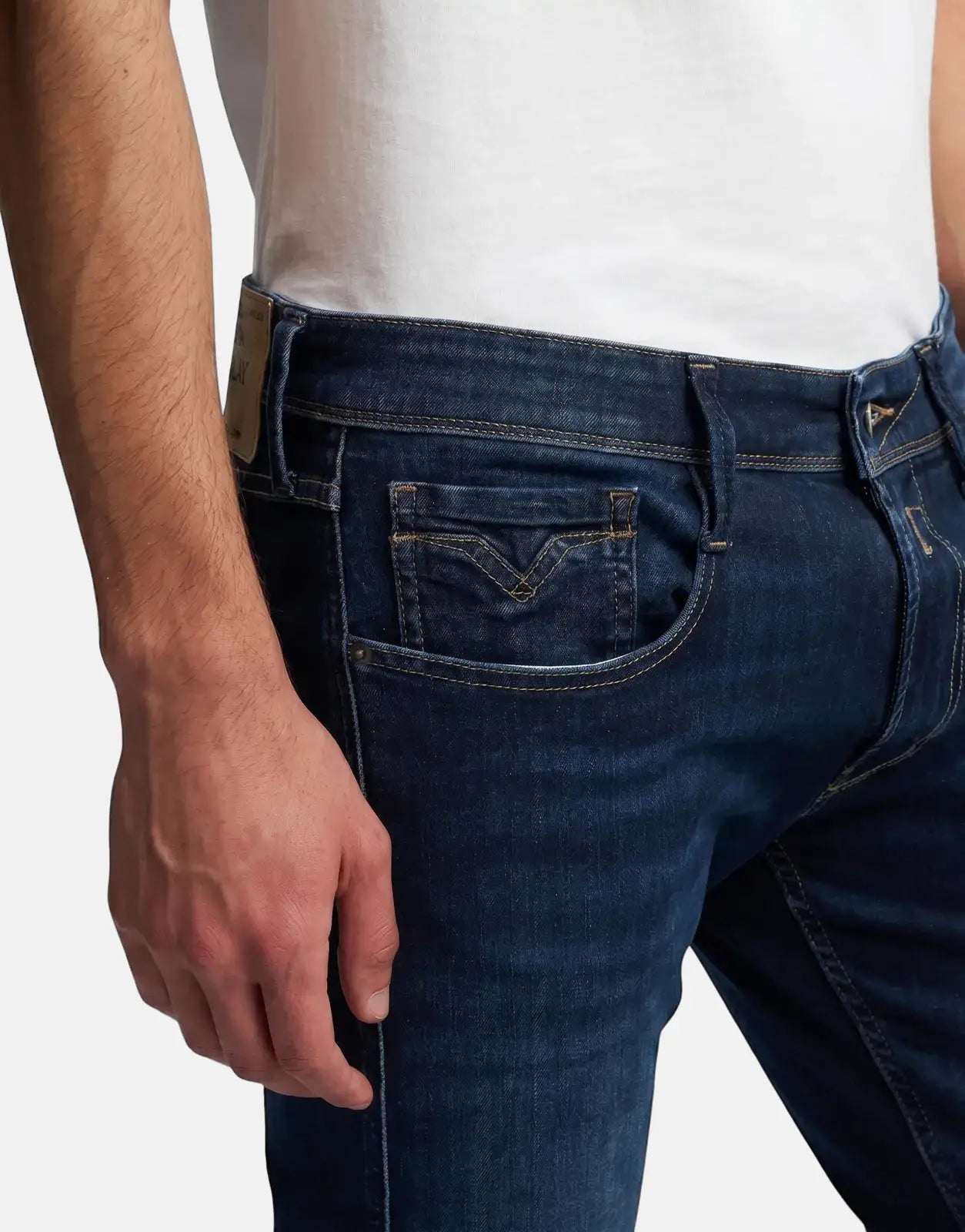 Close-up of a person wearing Replay Back Label Anbass dark blue denim jeans, showing the front pocket details.