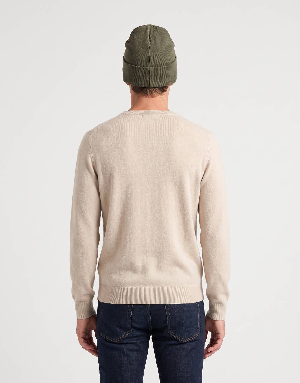 Back view of an adult wearing an olive green Replay Badge Winter Moss knit beanie, paired with a beige sweater and dark