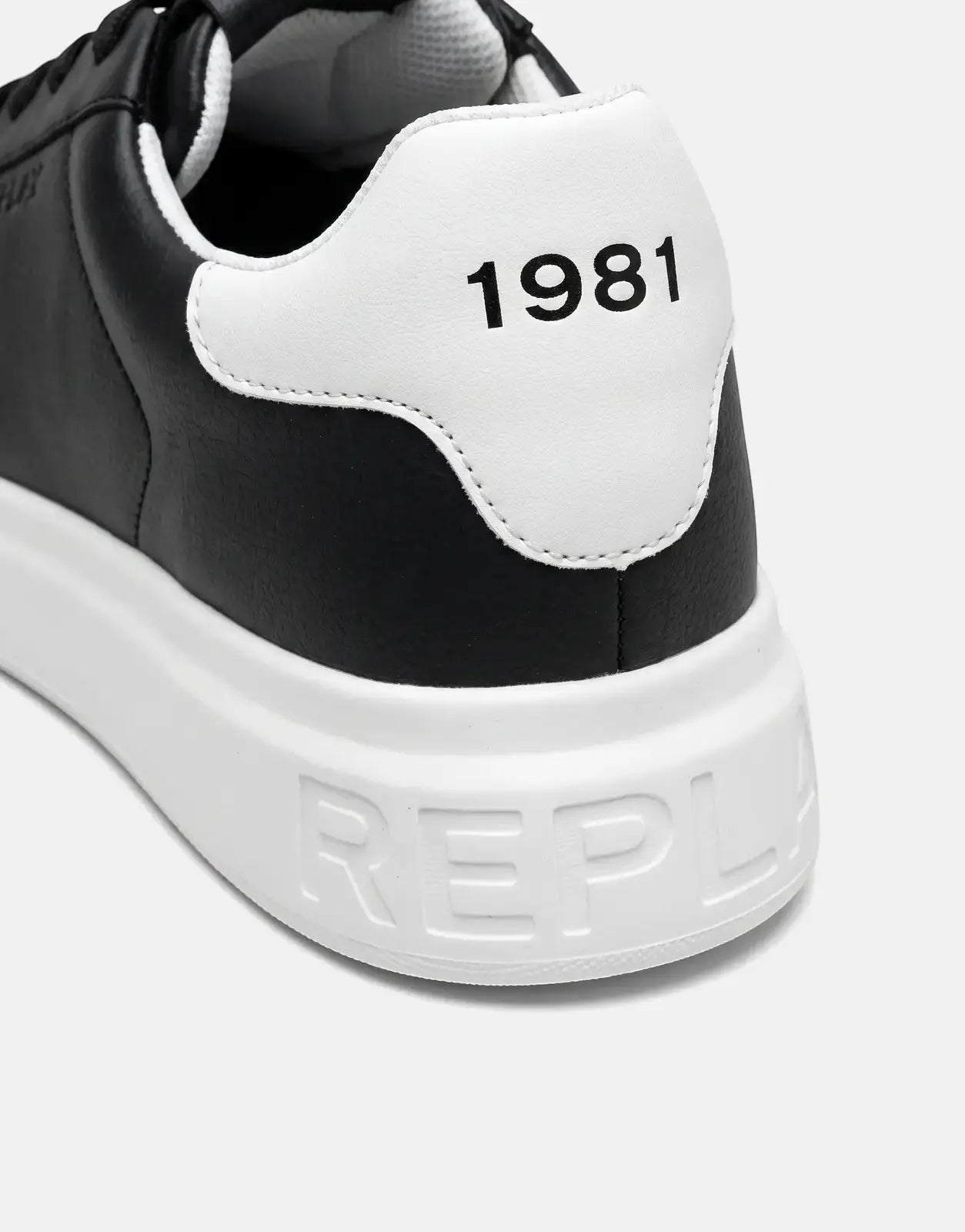 Close-up angled view of a black and white Replay Notting Medium Sneaker, featuring '1981' on the heel and 'REPLAY' on the