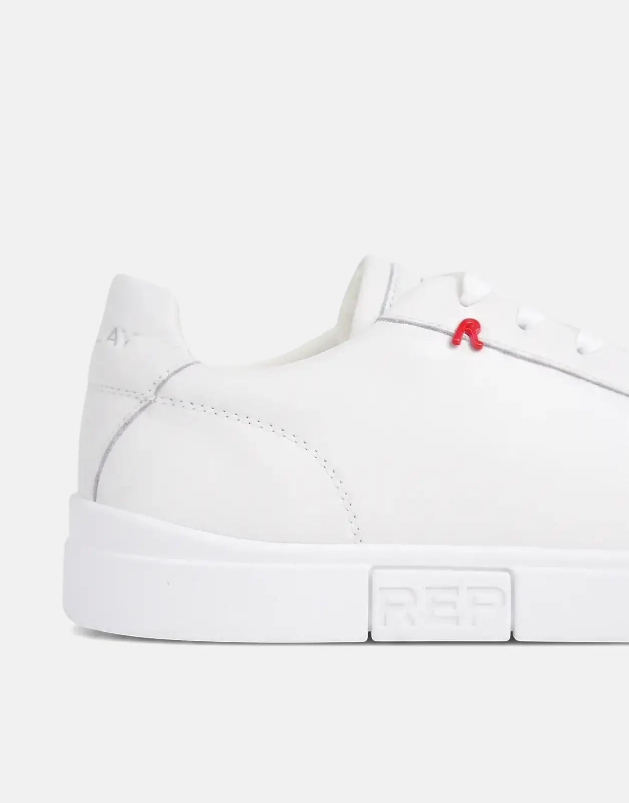 Close-up side view of a white leather Replay Poly R SA sneaker with a red R logo and 'REP' embossed on the sole.