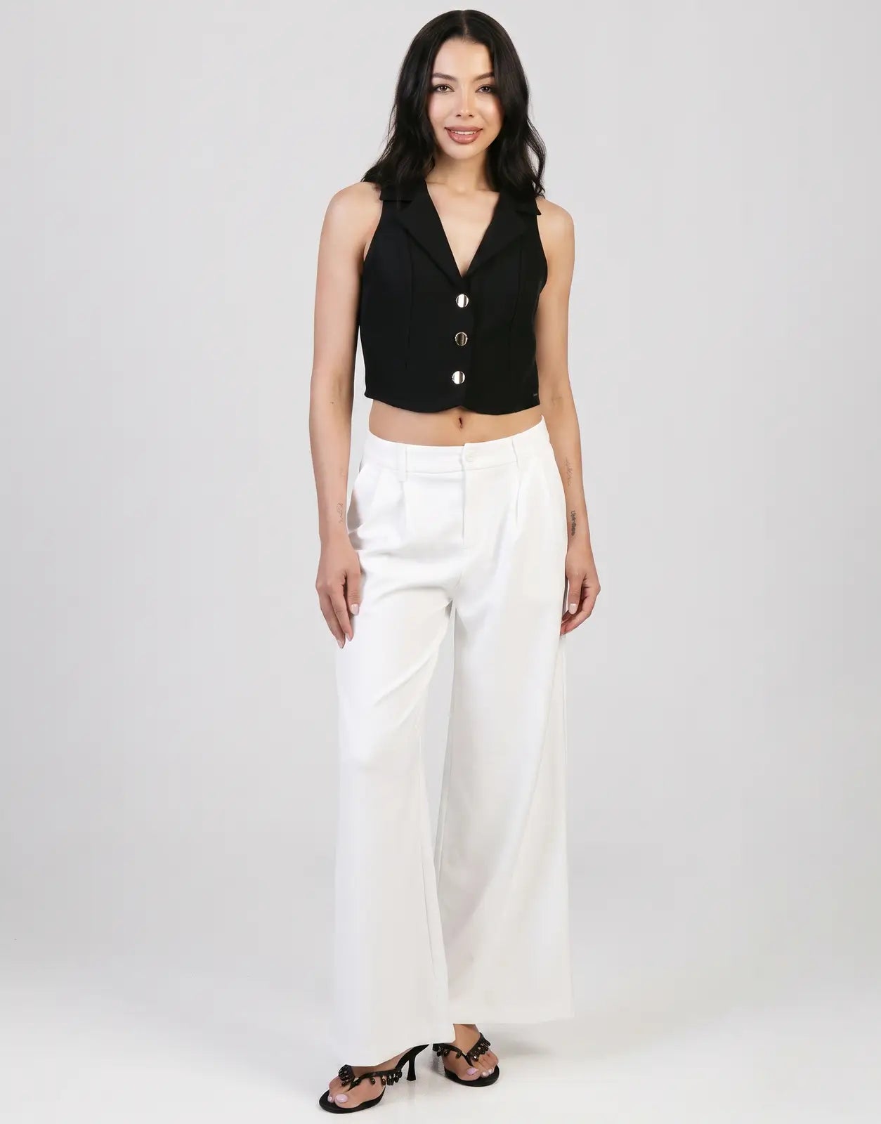 Sissy Boy Alice wide leg off-white trousers worn by a female model with a black sleeveless crop top and heels.