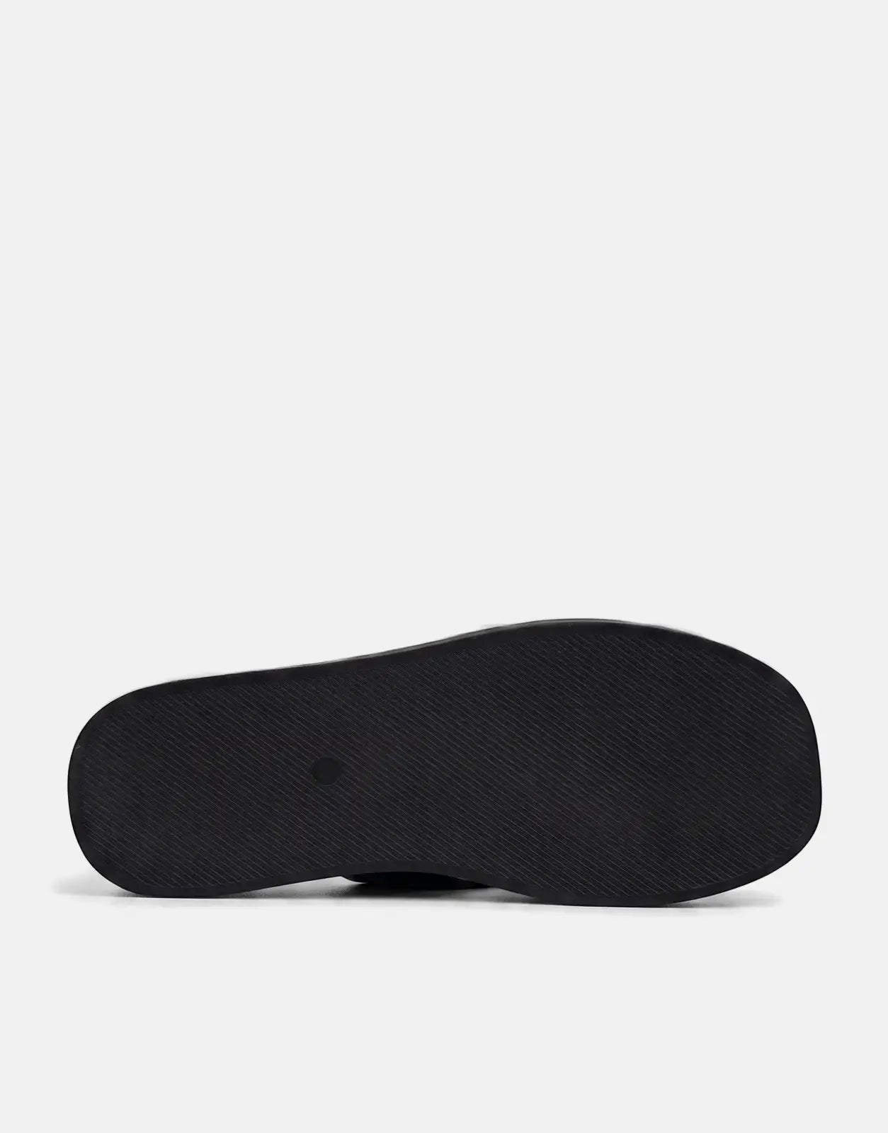 Sissy Boy Mimi Black Thong Sandals, view of the ribbed sole from underneath on a white surface.
