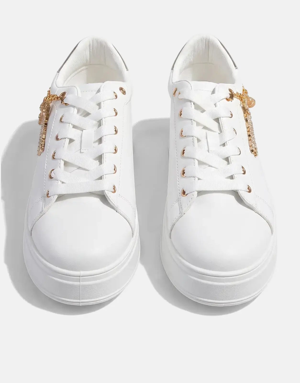 A pair of Sissy Boy Tatum white and gold sneakers with thick soles and rhinestone chain details, captured from a front-on