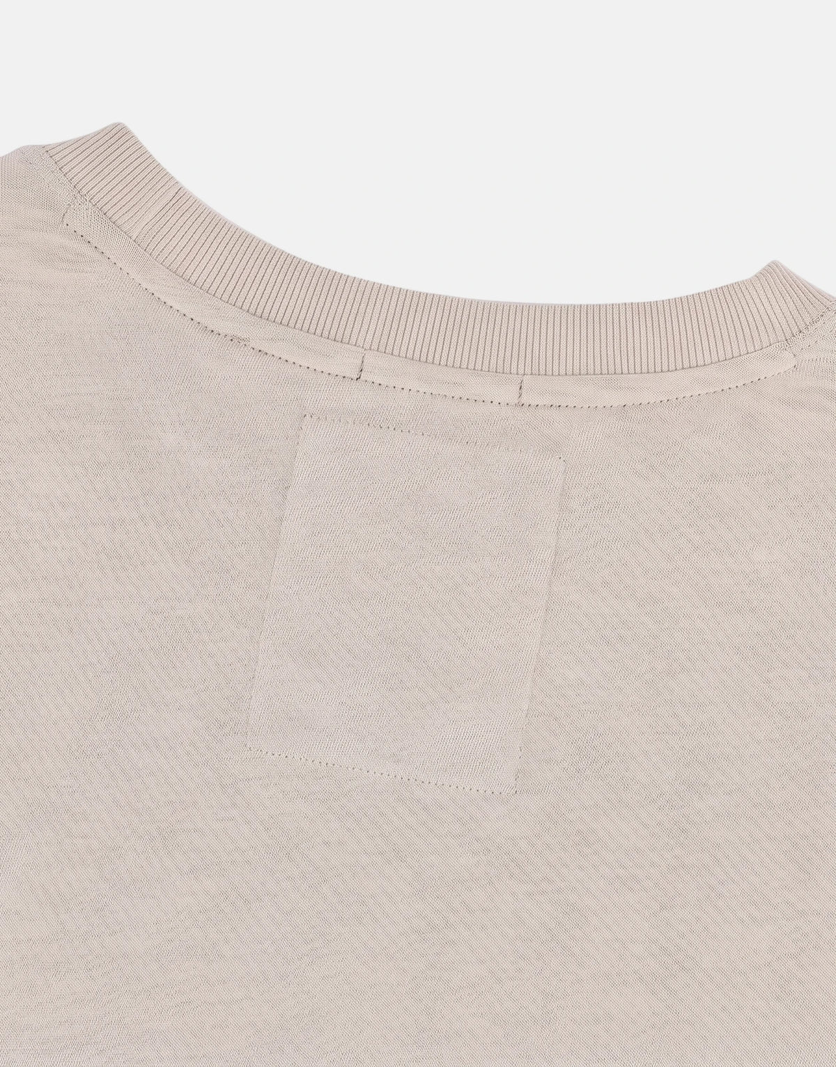 Close-up back view of a beige SPCC Troy Tee made from textured knit fabric, featuring a ribbed crewneck.