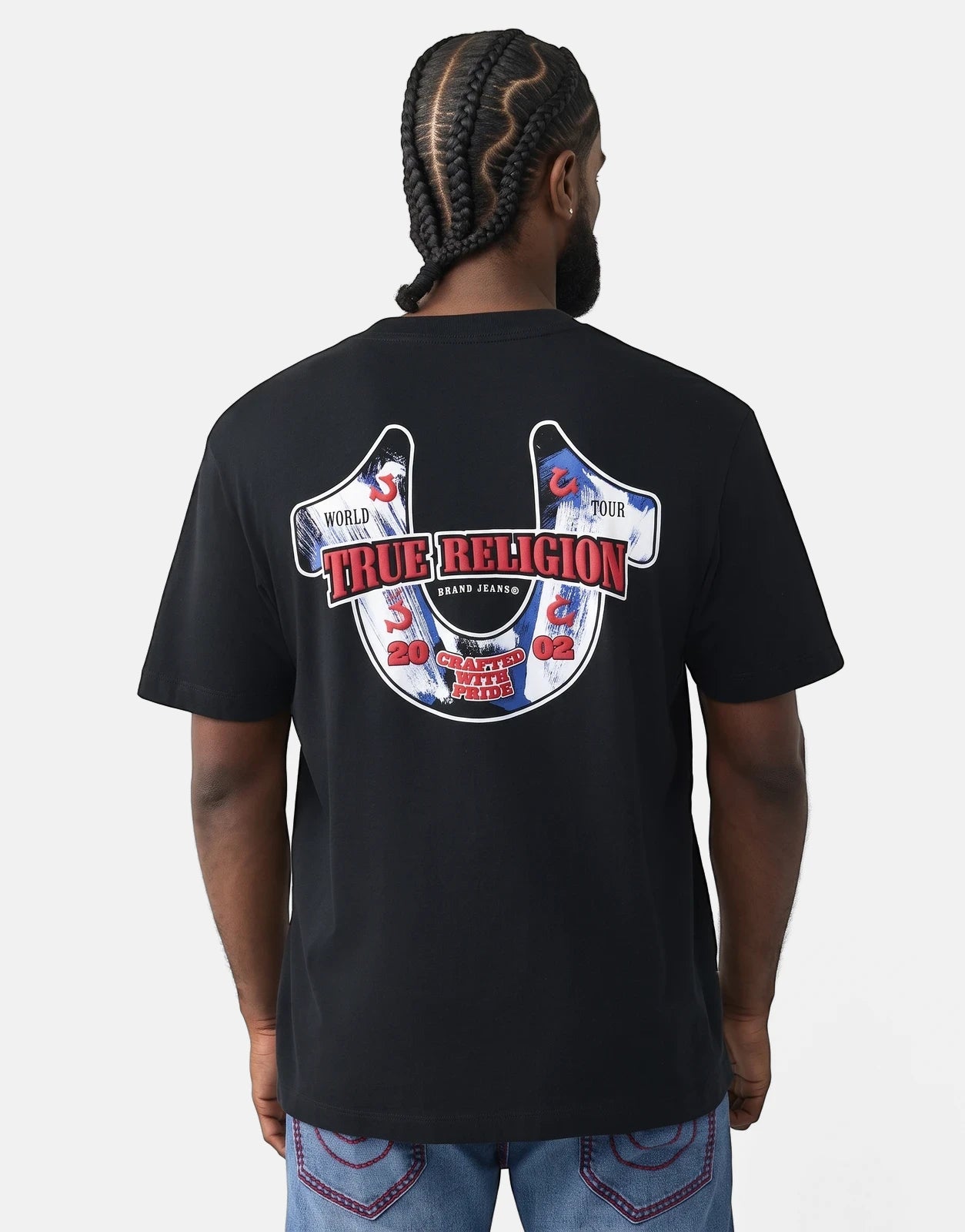 True Religion Abstract Denim T-Shirt in black, featuring a large red and blue horseshoe graphic on the back, worn by a man.