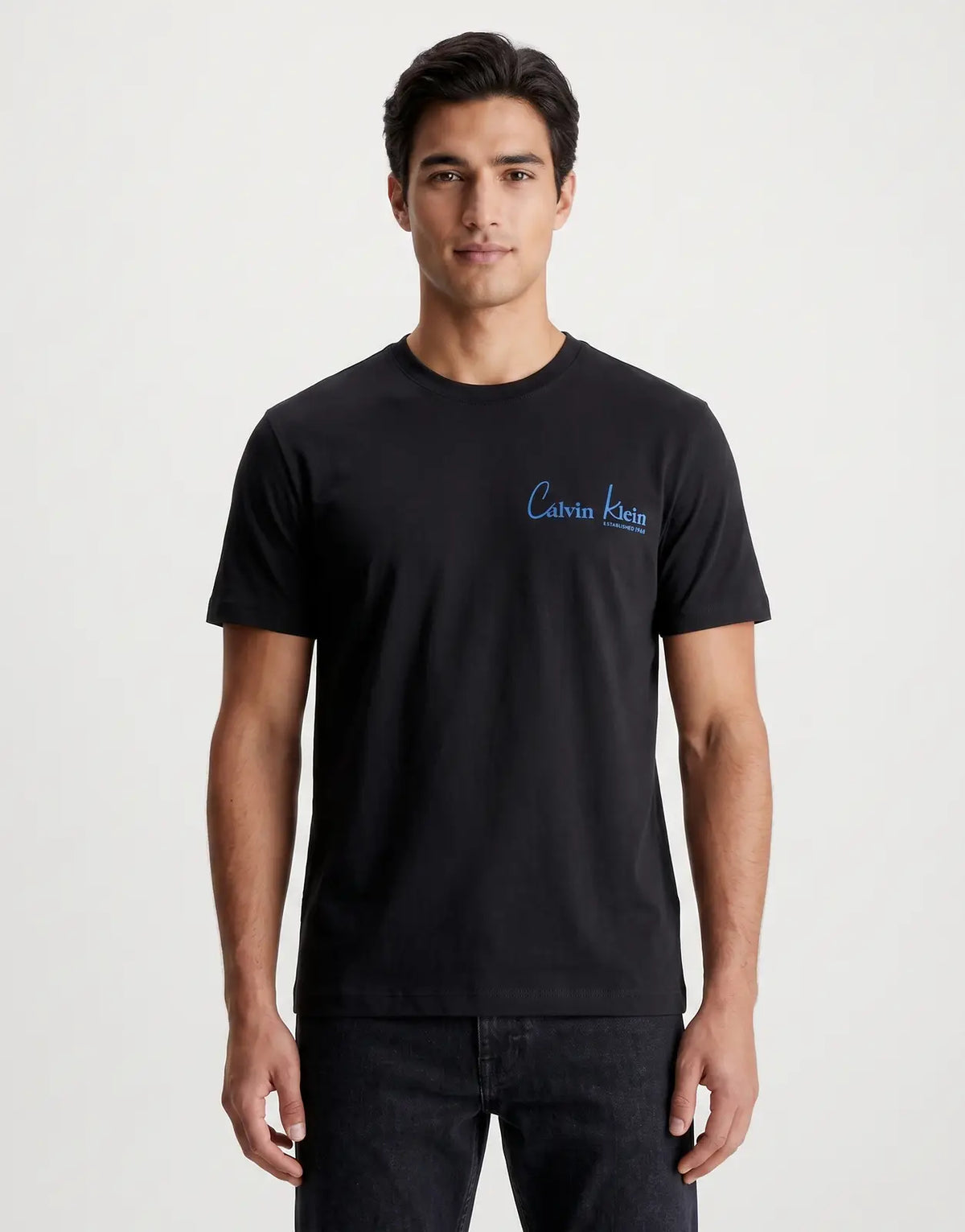 Black Calvin Klein 30s Wholesale Jeans graphic t-shirt for men, featuring a blue script logo on the front and short sleeves.