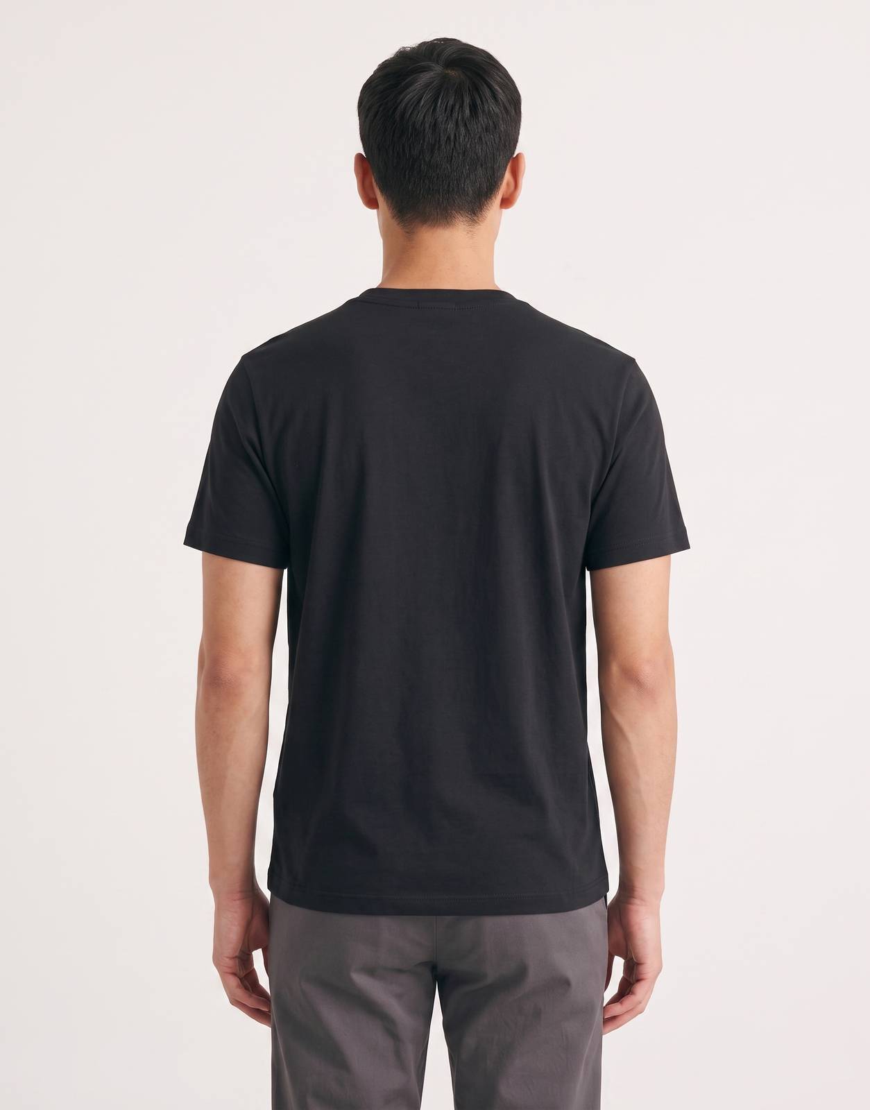 Calvin Klein 30s WHSL NYC Graphic Black T-Shirt for men, shown from the back on a model. The black t-shirt features a smooth