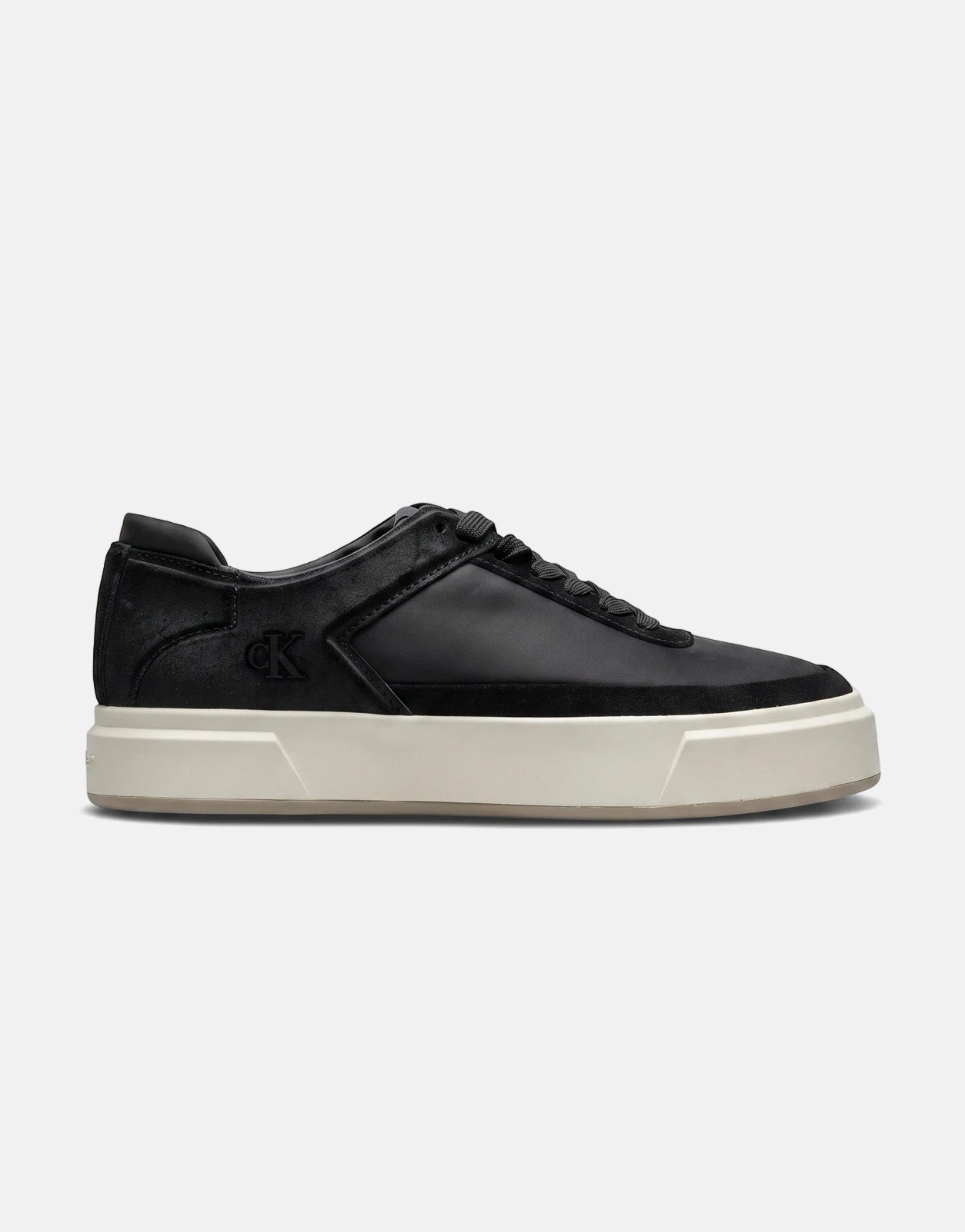 A side view of a black Calvin Klein Basket Cupsole lace-up sneaker with a cream sole, featuring the CK logo on the side.