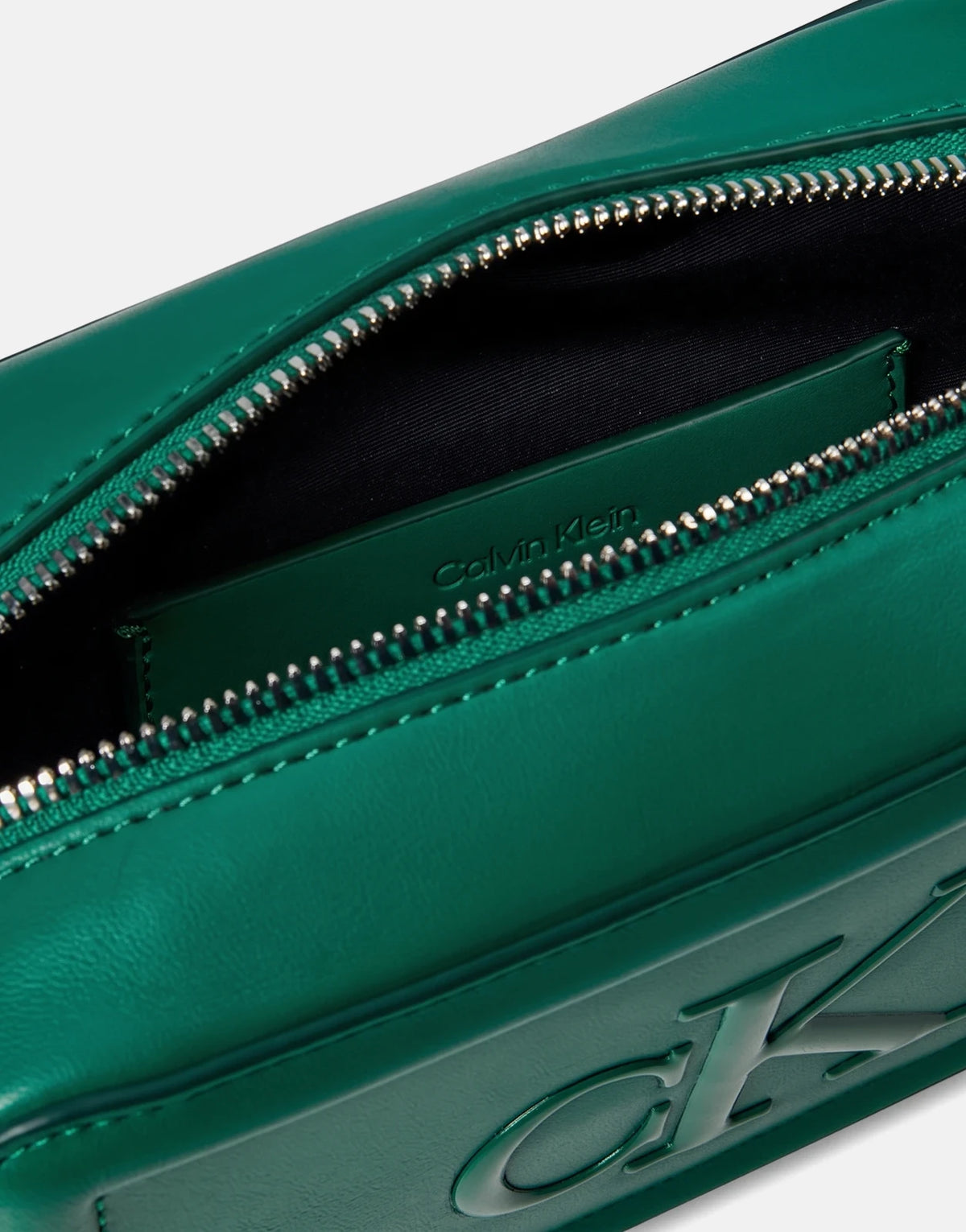 Close-up of an open Calvin Klein Bold CK Green Camera Bag, showcasing its emerald green leather material and silver zipper