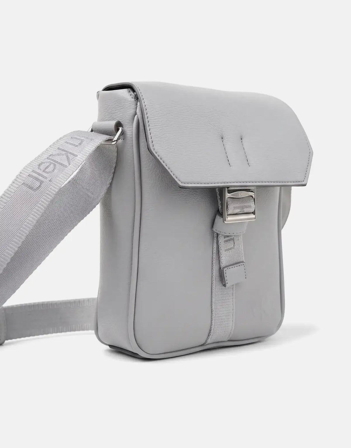 Grey Calvin Klein Cargo Flap Reporter Bag, a modern crossbody style made from textured material with buckle detail.