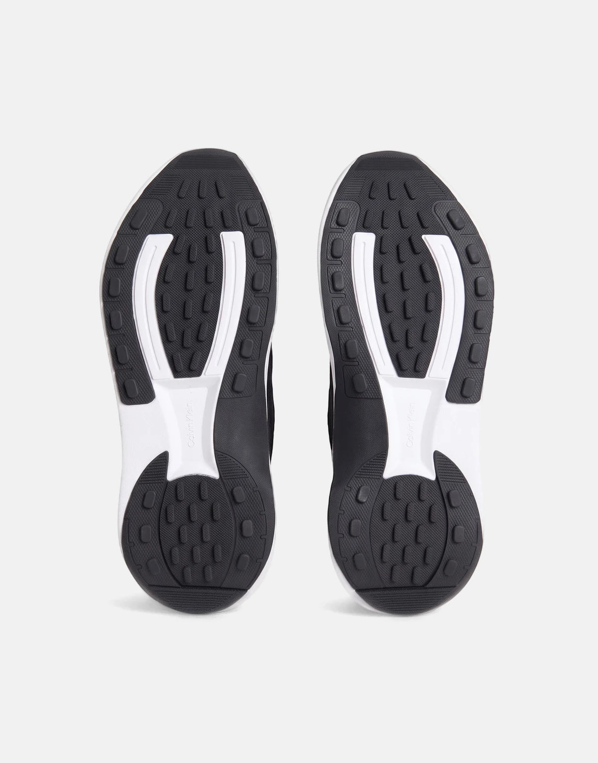 Pair of black and white Calvin Klein Chunky Run Lacesock Stripe sneakers, showcasing the detailed patterned rubber soles.