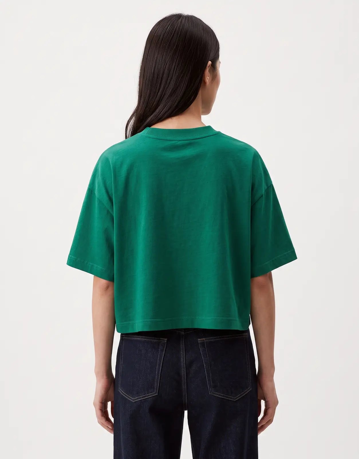 Back view of a model wearing a Calvin Klein Cropped Boxy Heritage Crest Logo Green T-Shirt, showcasing its relaxed fit and