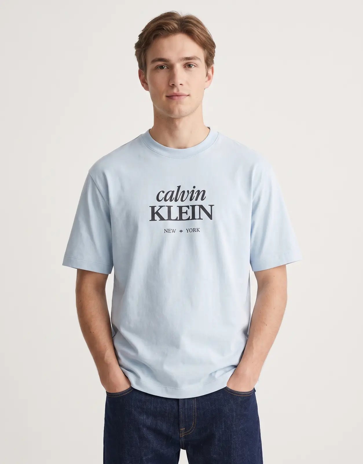 Light blue Calvin Klein 16s Diamond Graphic T-Shirt with black 'calvin KLEIN NEW YORK' branding on the chest, showcased from