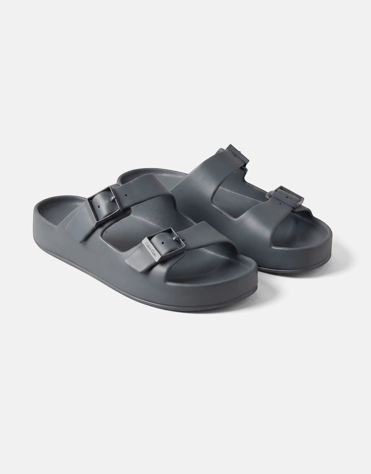 A pair of Calvin Klein Ergon Eva Double Bar sandals in blue-grey, made from EVA, shown from a slightly elevated side view.