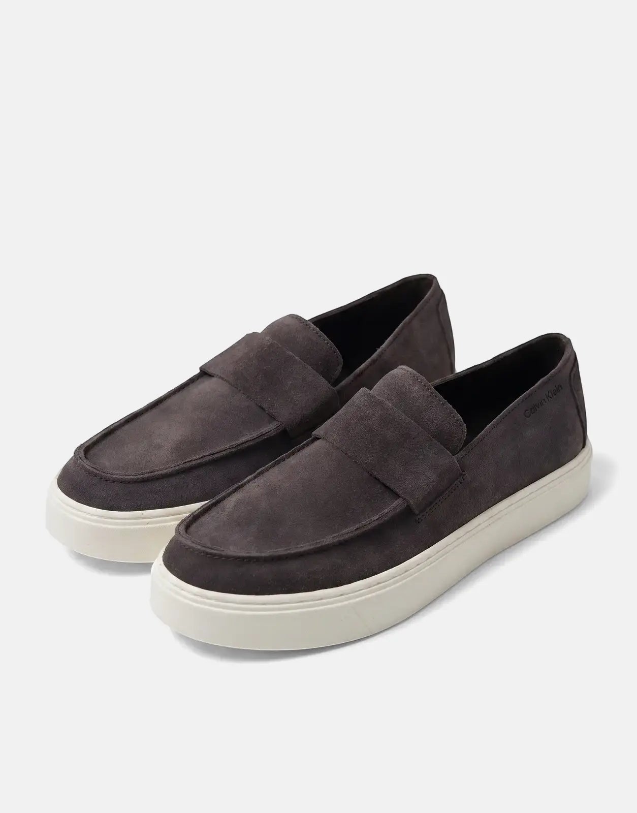 A pair of Calvin Klein Hybrid Clean Cup Dark Brown Loafers with prominent white soles, showcased from an elevated view on a