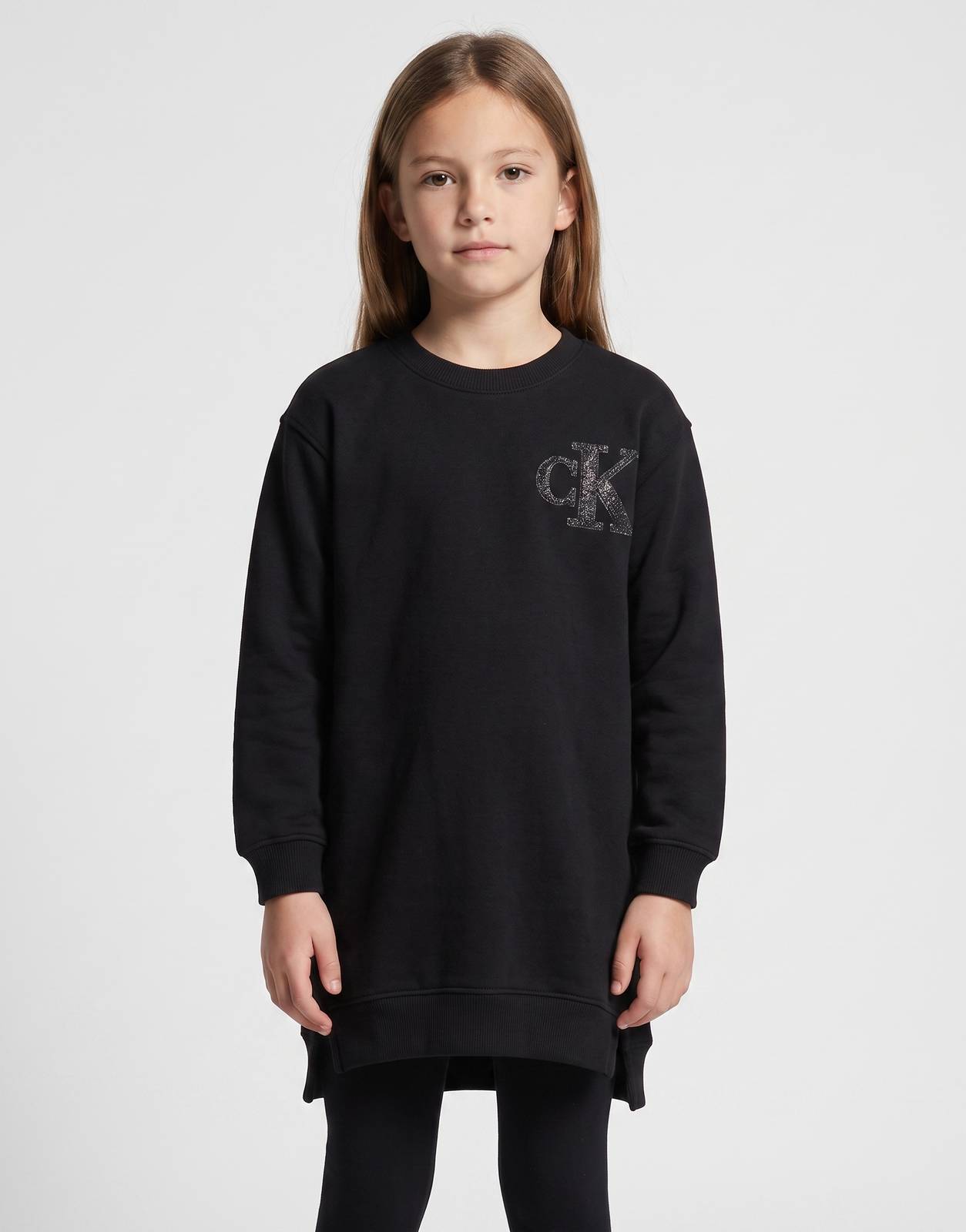 Calvin Klein Kids black long-sleeve terry dress with a glitter 'CK' logo, shown from the front on a child model.