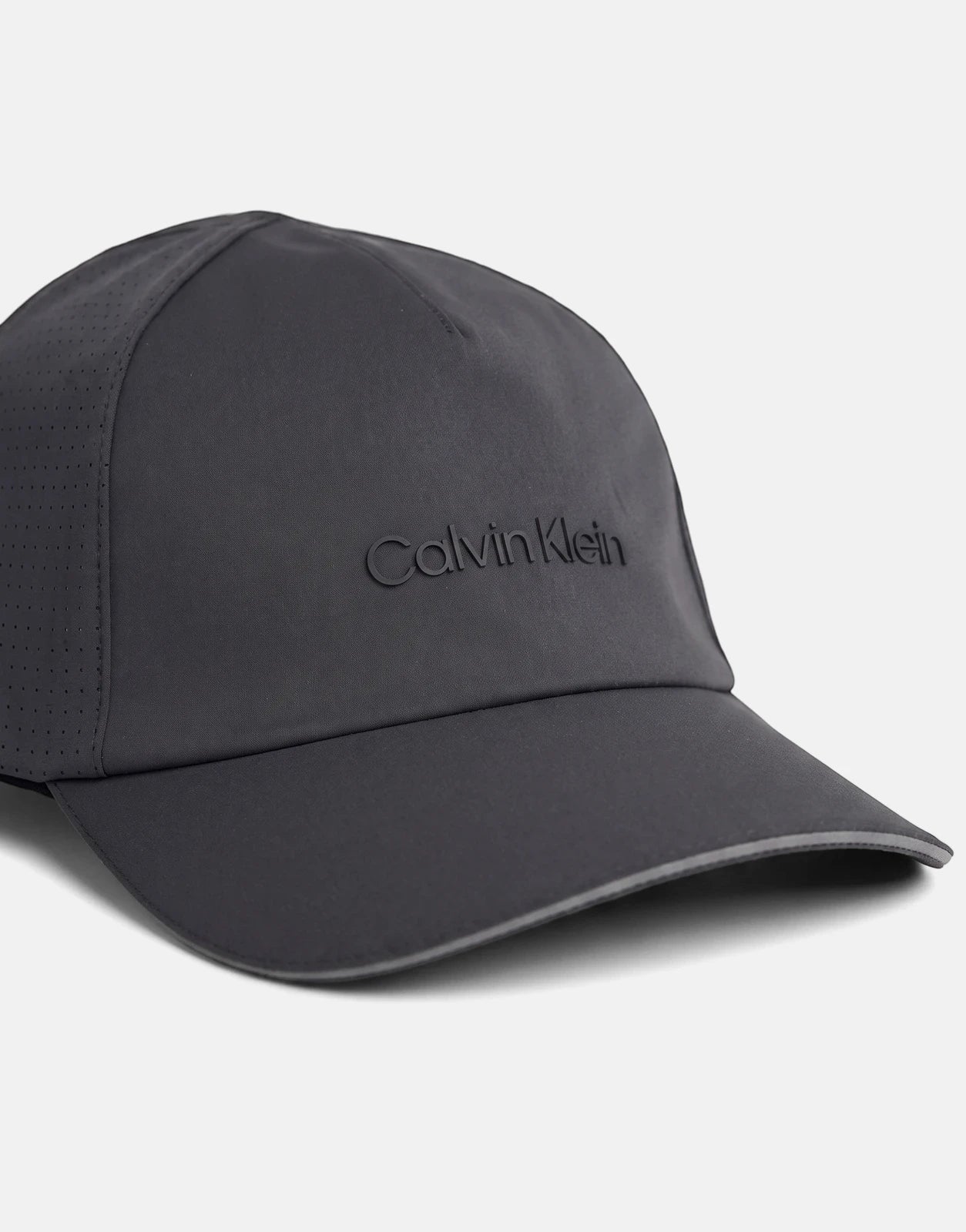 Dark grey Calvin Klein Micro Twill silicone trucker cap, angled front view, showcasing perforated side panel.