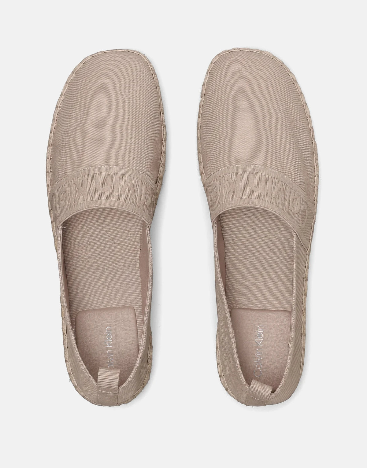 Top-down view of two light brown Calvin Klein Oblique Espadrille Webbing canvas slip-on shoes with espadrille soles and
