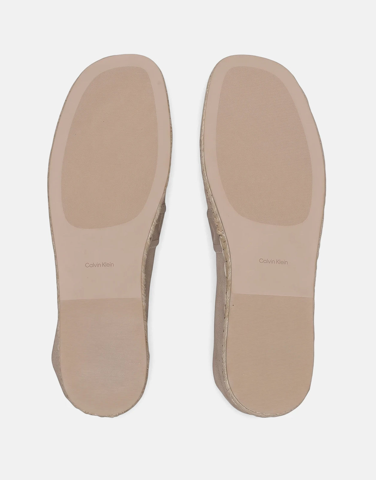 Bottom view of two Calvin Klein Oblique Espadrille Webbing shoes in light brown, showcasing textured soles and logo.