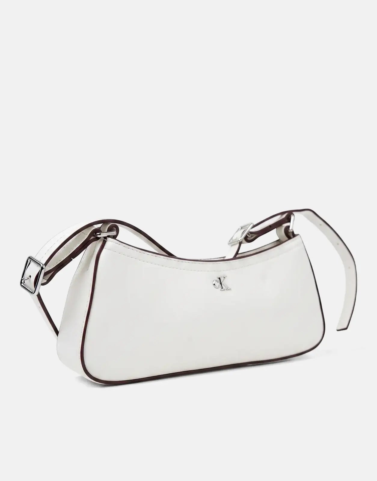 Small white Calvin Klein shoulder bag with silver hardware and brown trim, resting on a clean white surface.