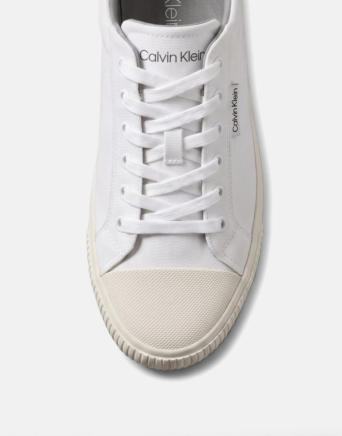 White canvas Calvin Klein Vulc Low Laceup sneaker, shown from a top-down view, highlighting its laces and branding.