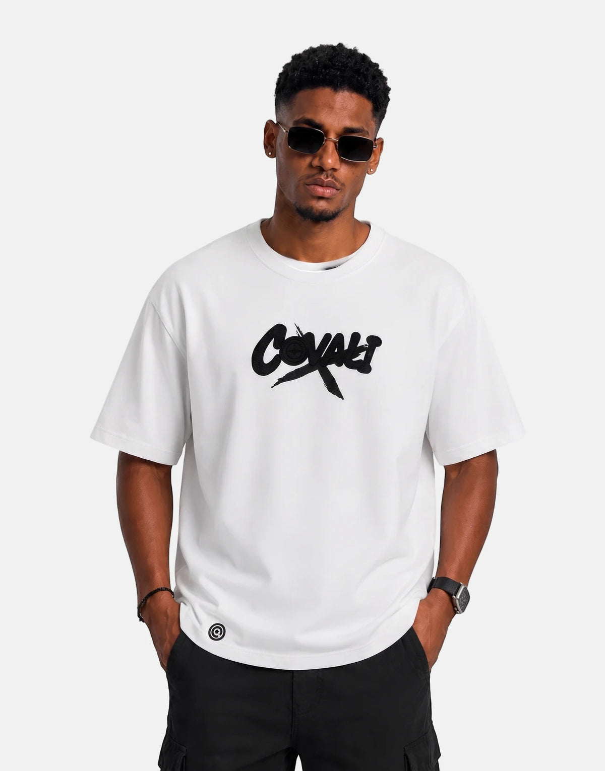 Covali Denimo white oversized short-sleeve t-shirt with black logo, worn by a male model in a studio setting.