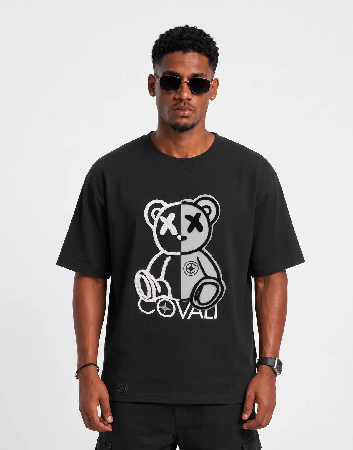 Covali Forzi Black T-Shirt with split-face teddy bear graphic, worn by a male model with sunglasses.