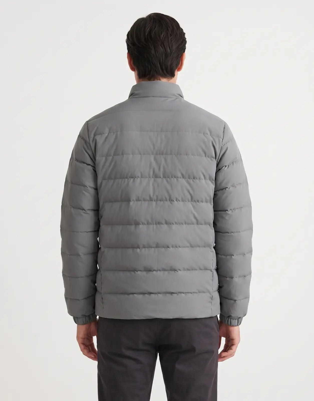 Back view of a gray Covali Inverno Puffer Jacket on a male model. The jacket features horizontal quilting and a stand-up