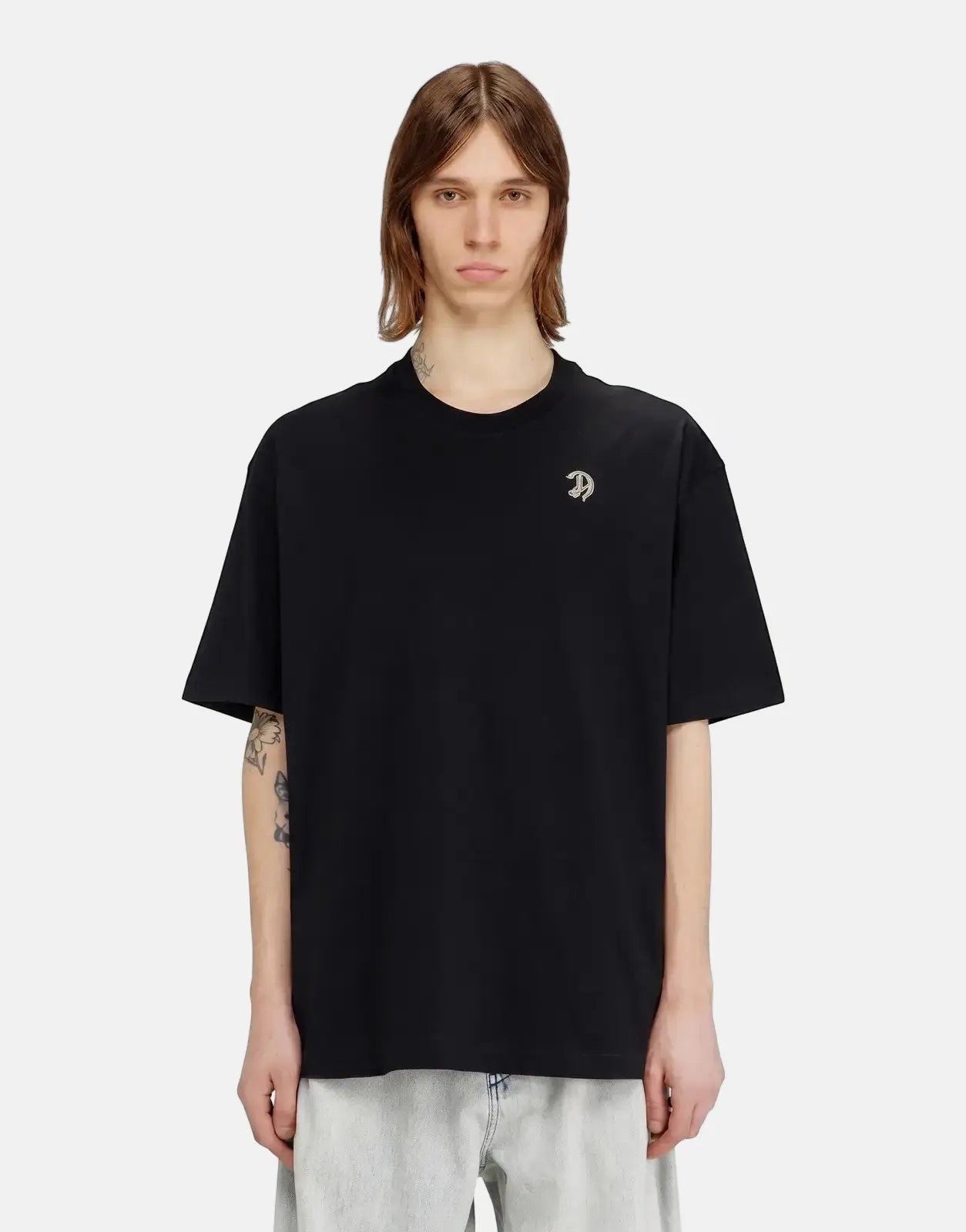 Male model wearing a black Diesel T-Boggy V2 oversized short-sleeve t-shirt with a silver D logo.