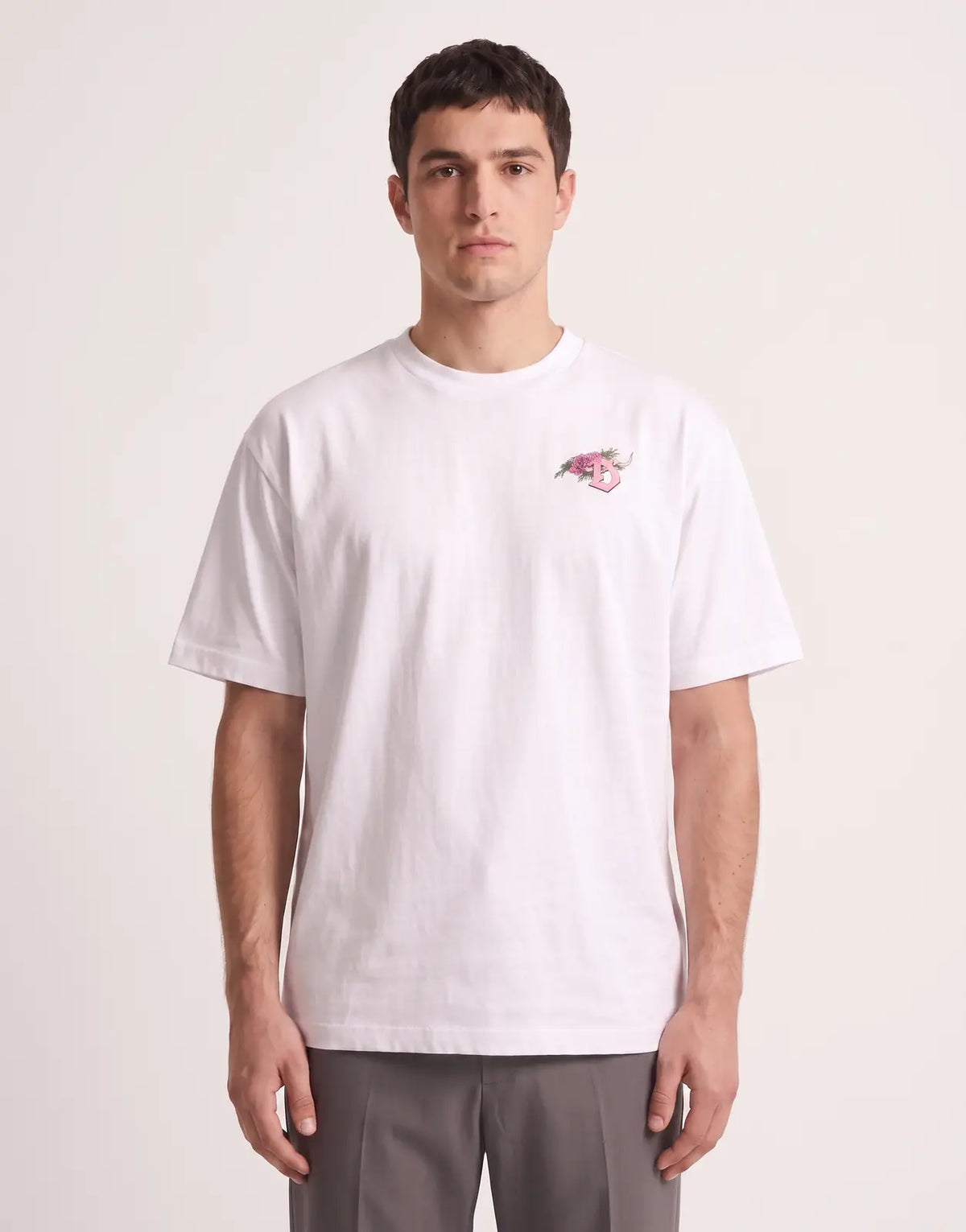 Front view of a white Diesel T-Boggy V4 Relaxed T-Shirt 100 featuring a pink rose 'D' graphic on the chest, worn by a male