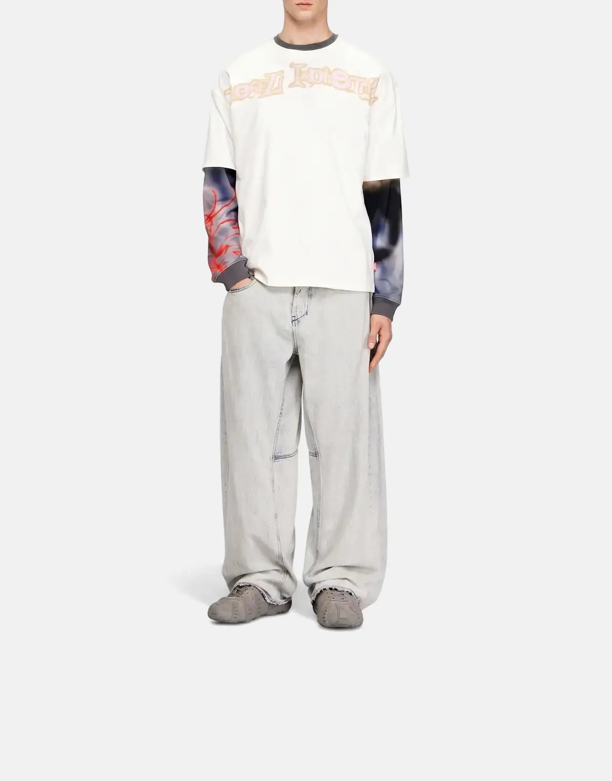 Male model wears a white Diesel T-Boxt V3 relaxed fit graphic t-shirt over a patterned long-sleeve, with baggy light wash