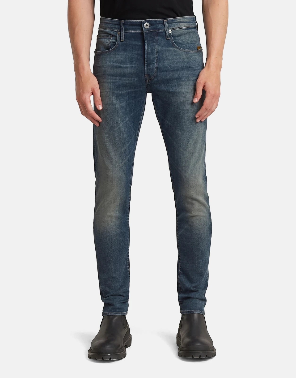 G-Star RAW 3301 Slim Faded Worker Blue Jeans, modeled with black boots. Slim-fit, faded blue jeans with visible pockets and