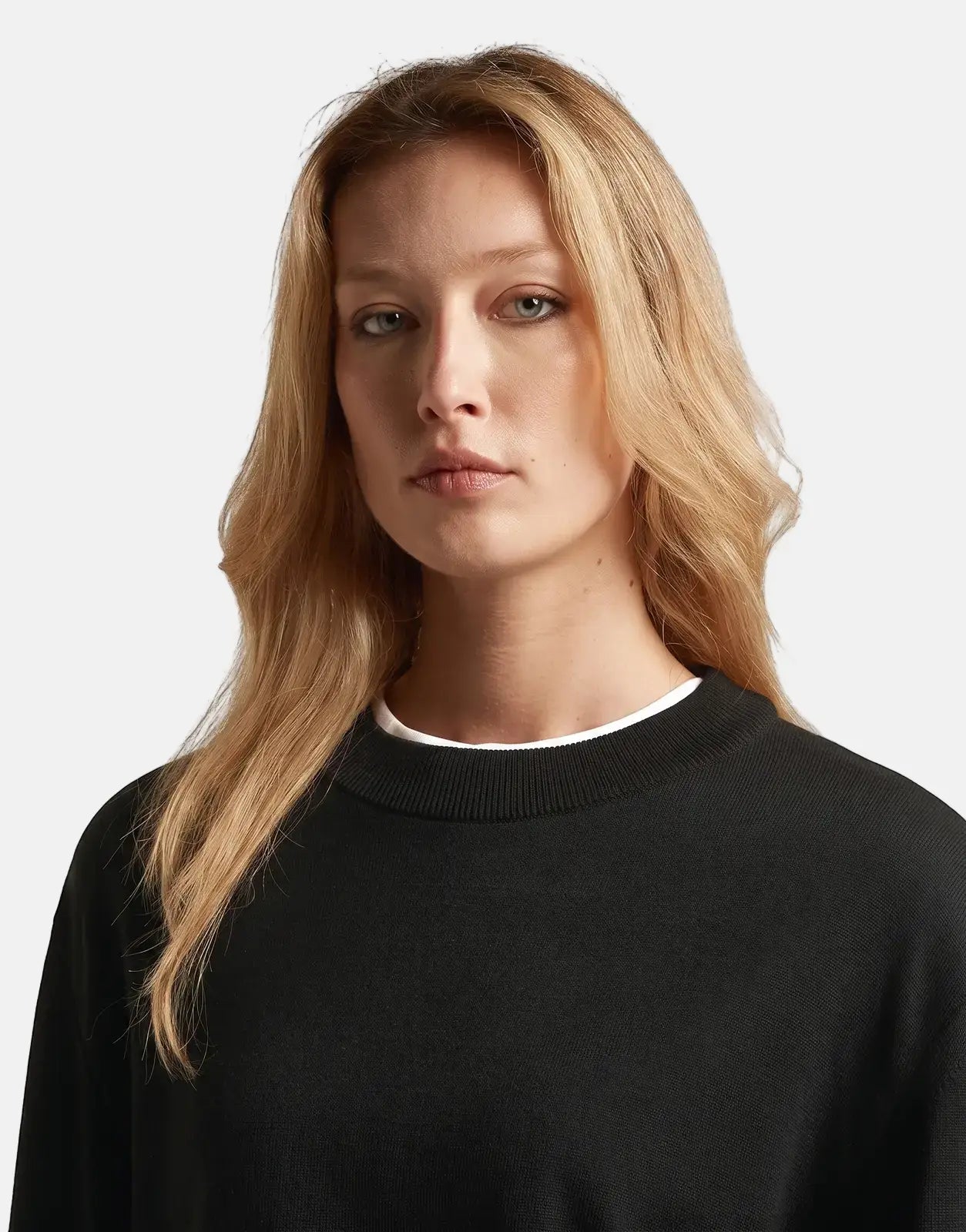 Blonde model wearing a G-Star RAW Boxy Knit Dk Black sweater, shot in a close-up with a neutral expression.