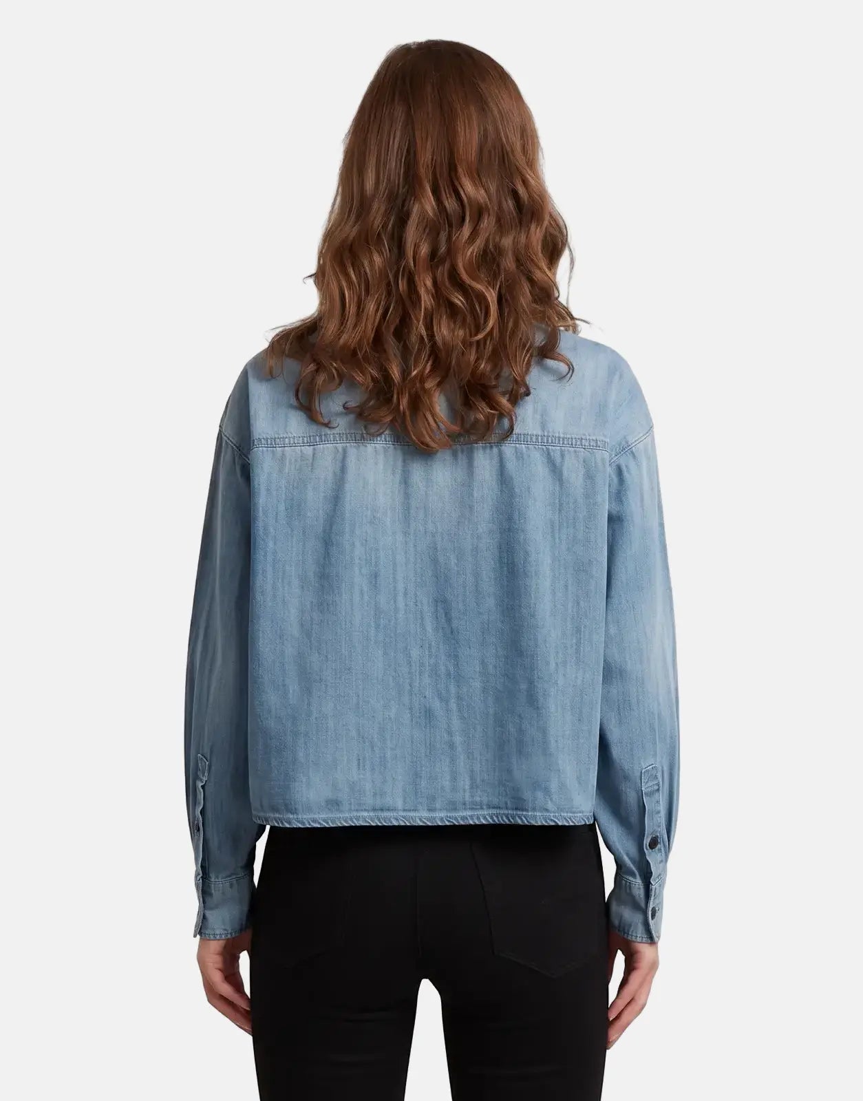 Back view of a woman wearing a G-Star RAW Cropped Relaxed Shirt in faded cadet blue, featuring long sleeves.
