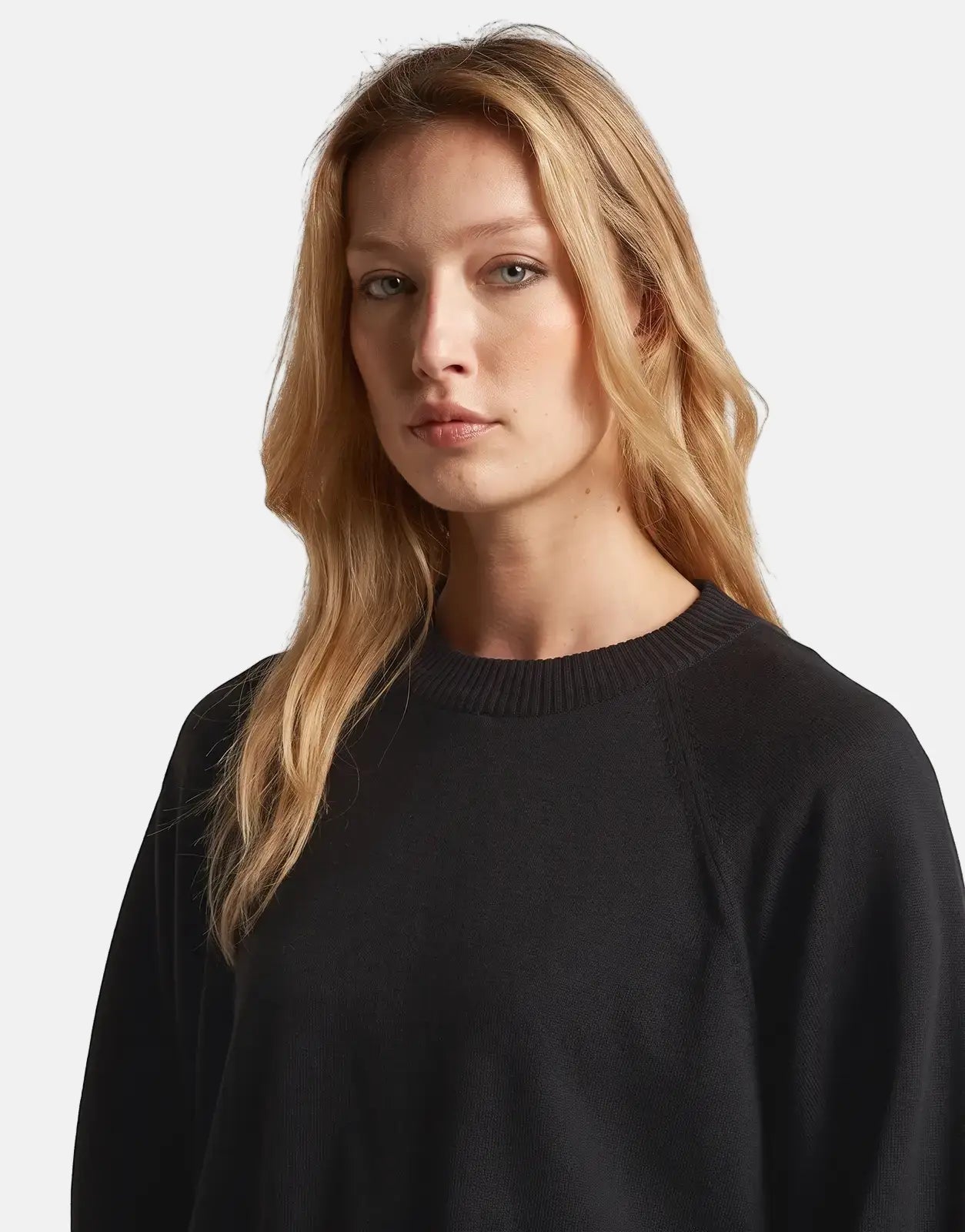 Woman wearing a G-Star RAW Dk Black Raglan Top, detailed studio shot showing the ribbed neckline and knit fabric.