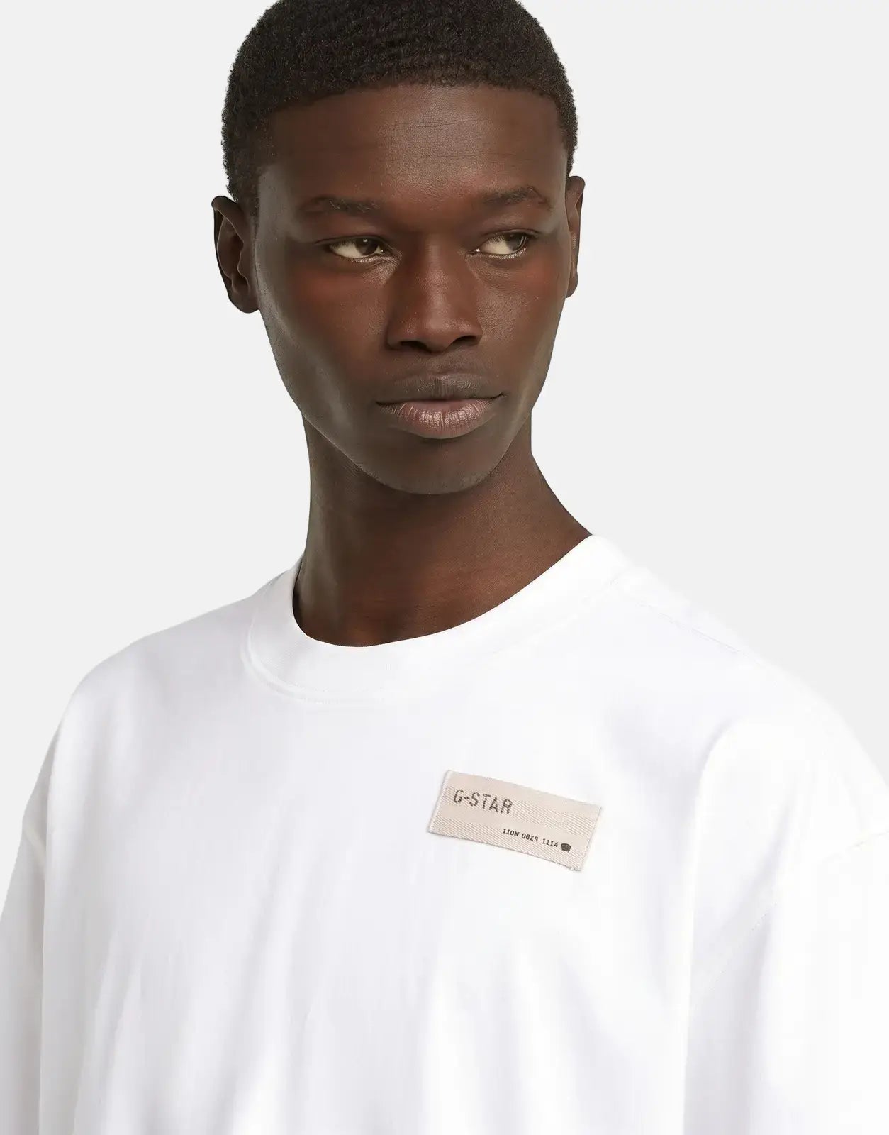 G-Star RAW HB Badge Relaxed White T-Shirt worn by a male model, showcasing the logo badge on the chest.