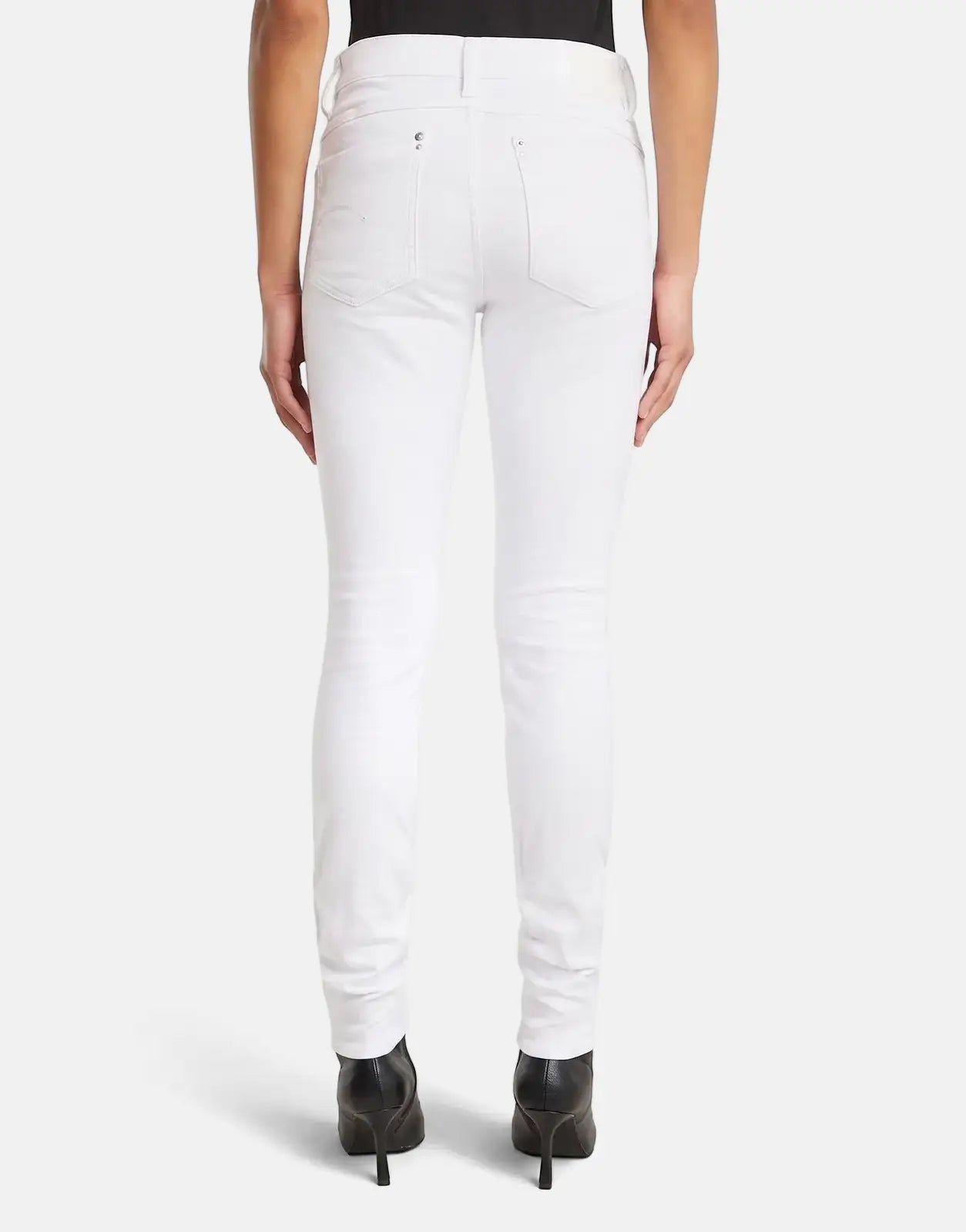 Rear view of women's G-Star RAW Lhana skinny paper white jeans, showcasing the fit, pocket details, and black heels.