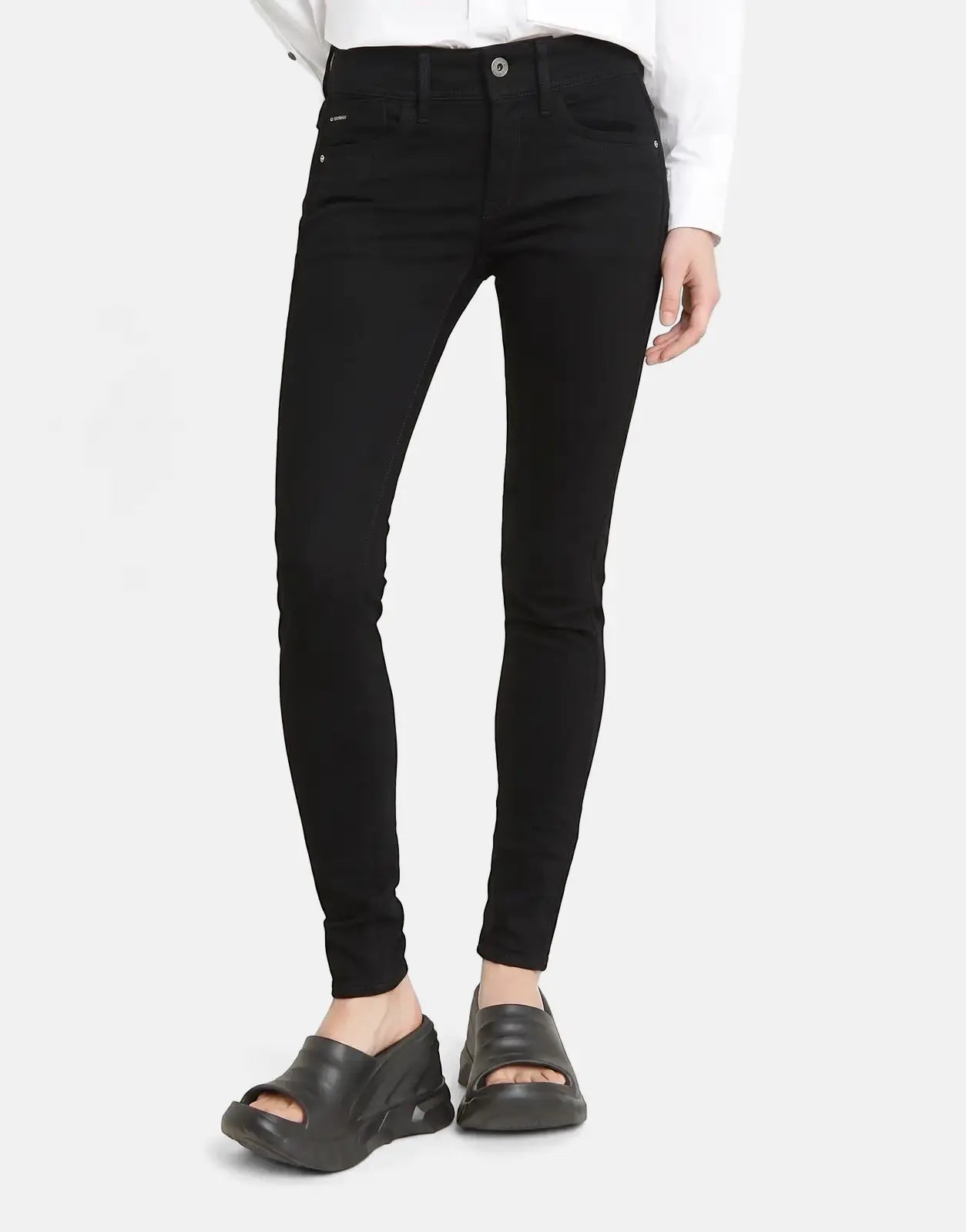 A person models G-Star RAW Lynn Mid Skinny Pitch Black Jeans, showcasing the slim fit and dark wash.