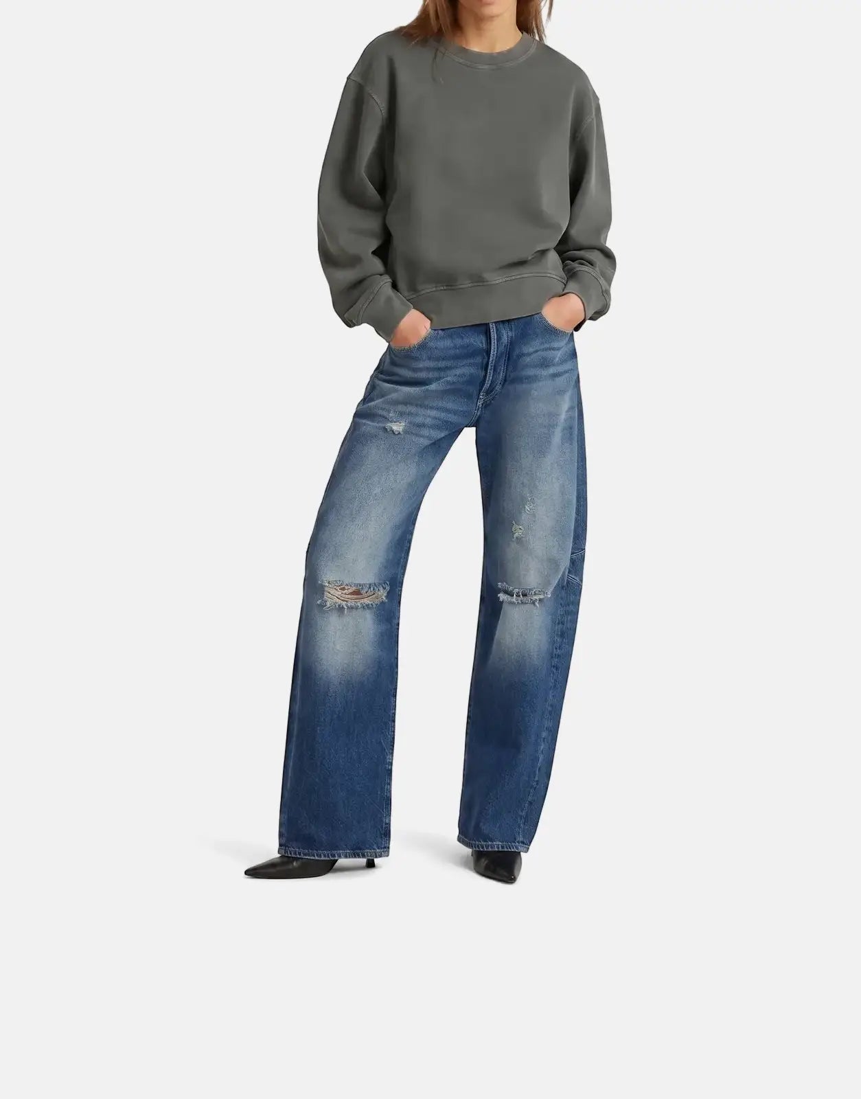 Female model wearing a dark grey G-Star RAW Modern Basic Relaxed sweatshirt and distressed wide-leg blue jeans.