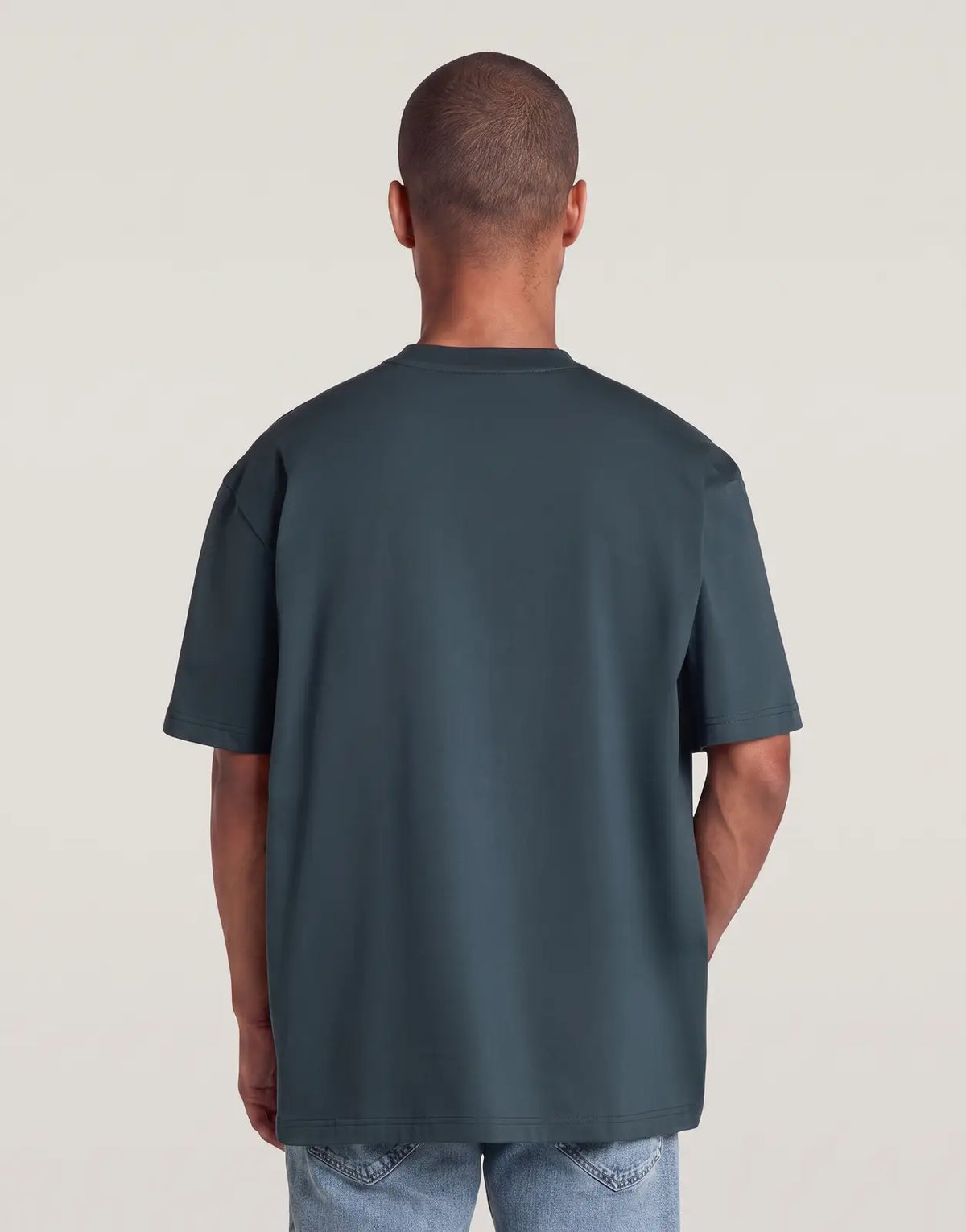 Back view of a man wearing a G-Star RAW Multi Technique Relaxed Vintage Navy T-Shirt, showcasing its dark blue fabric and