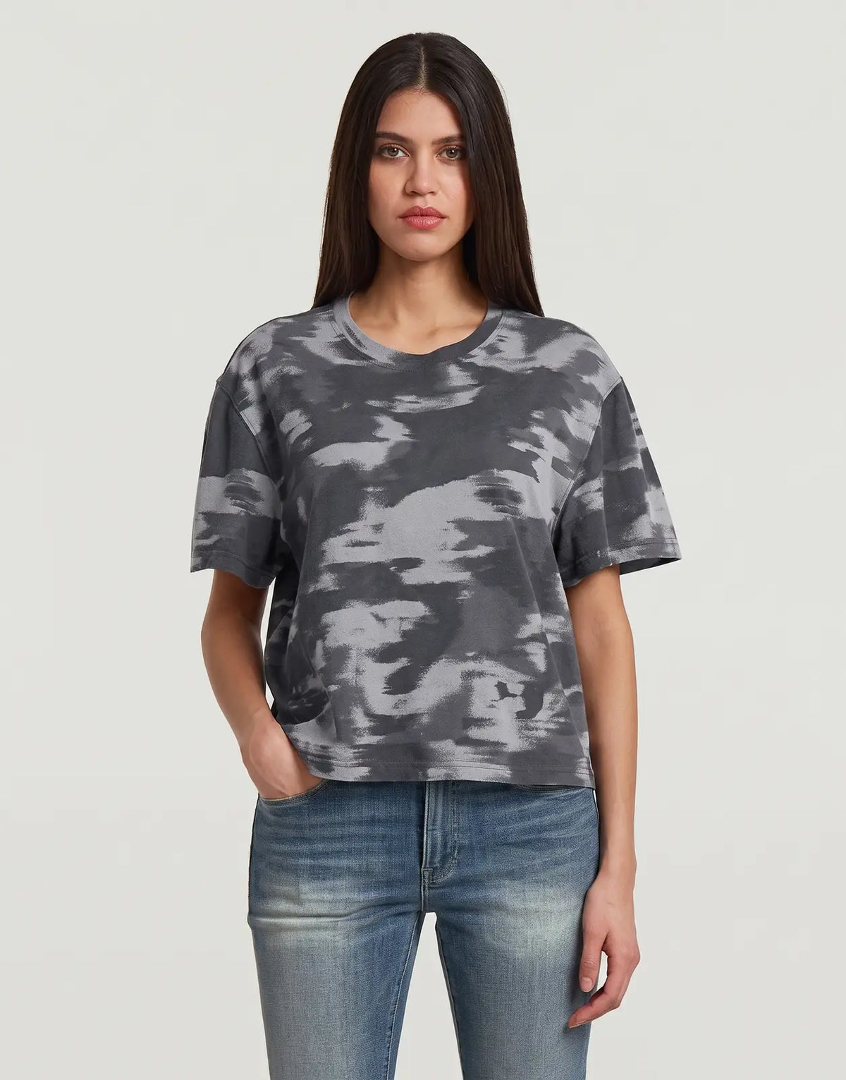 A woman wears a G-Star RAW Regular Camo T-Shirt Keian Motion, featuring a grey camouflage pattern and short sleeves.