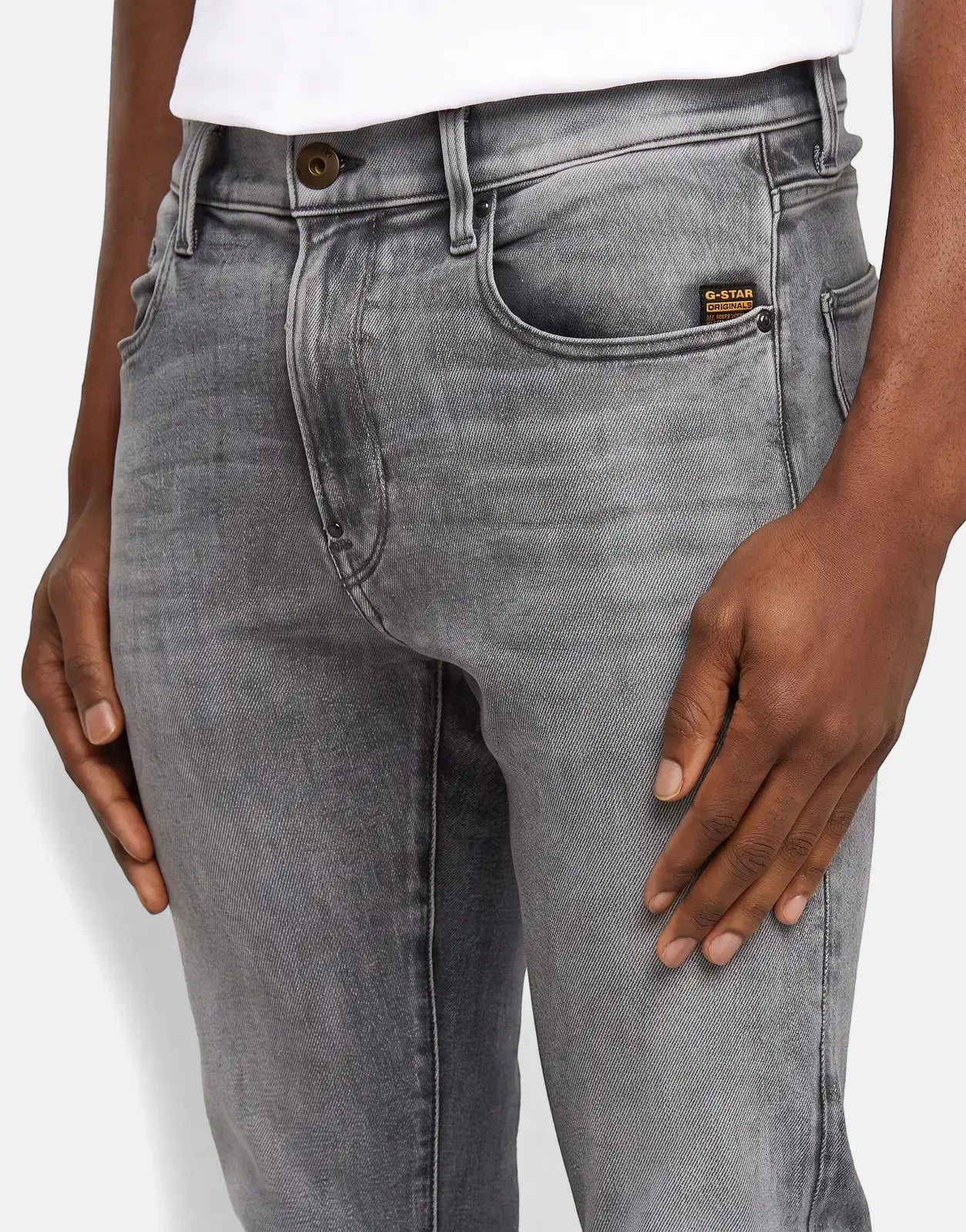 Close-up of a model wearing G-Star RAW Revend FWD Skinny Faded Shadow Grey jeans, featuring detailed stitching and a brand