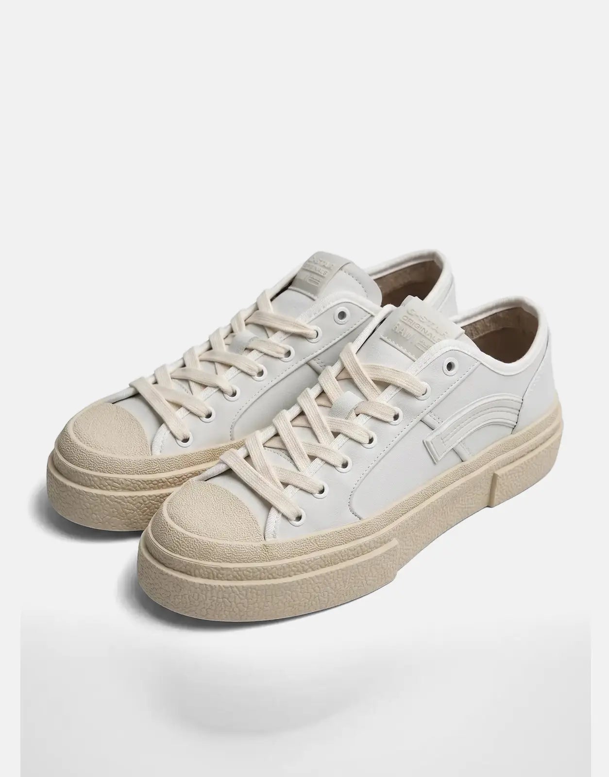 Pair of G-Star RAW Vodan Low Lea white leather sneakers with cream soles and laces, displayed on a flat surface.