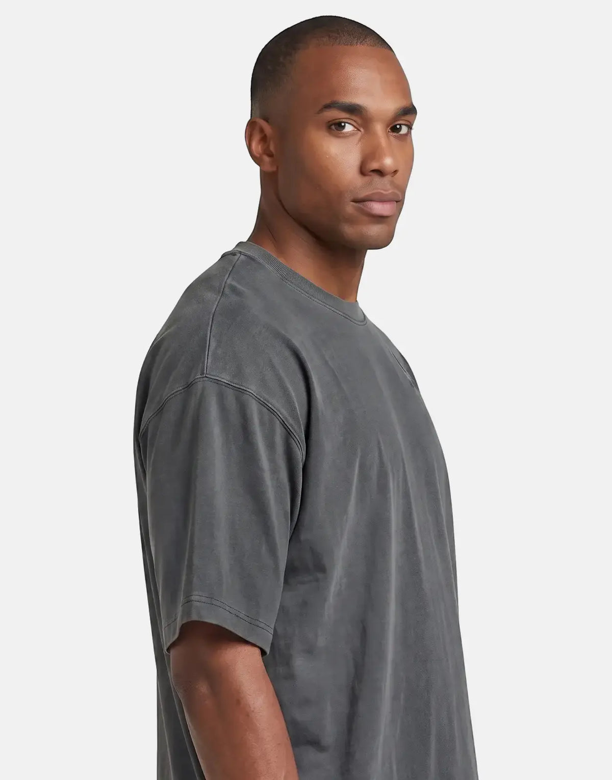 A male model wearing a dark grey G-Star RAW Washed Multi GR oversized t-shirt, seen from the waist up.