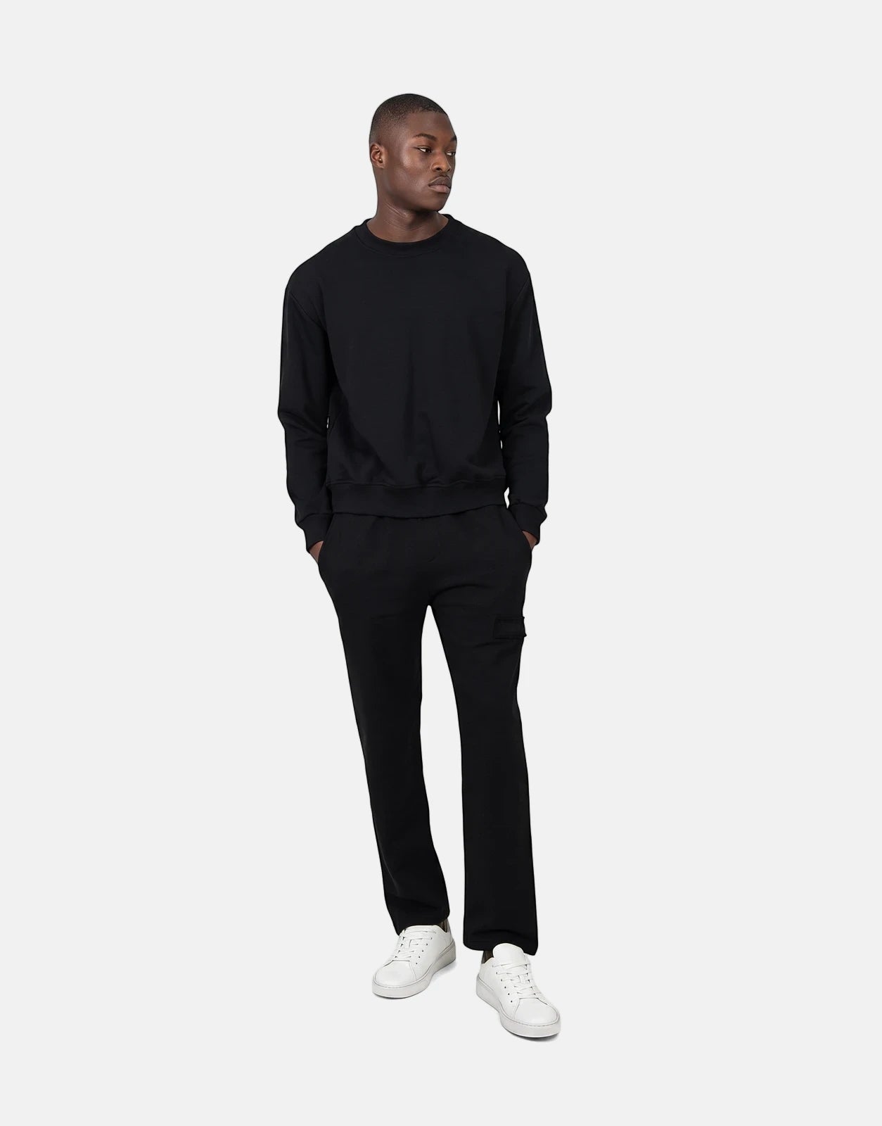 Les Hommes Black Jogger worn by a male model, styled with a black sweatshirt and white sneakers, offering a comfortable,