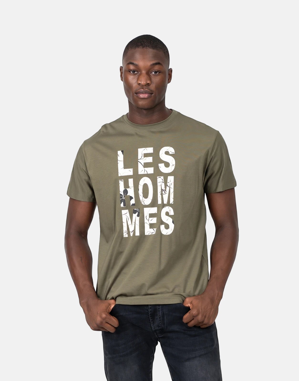Olive green Les Hommes chest graphic t-shirt modeled by a man, featuring a distressed white logo.
