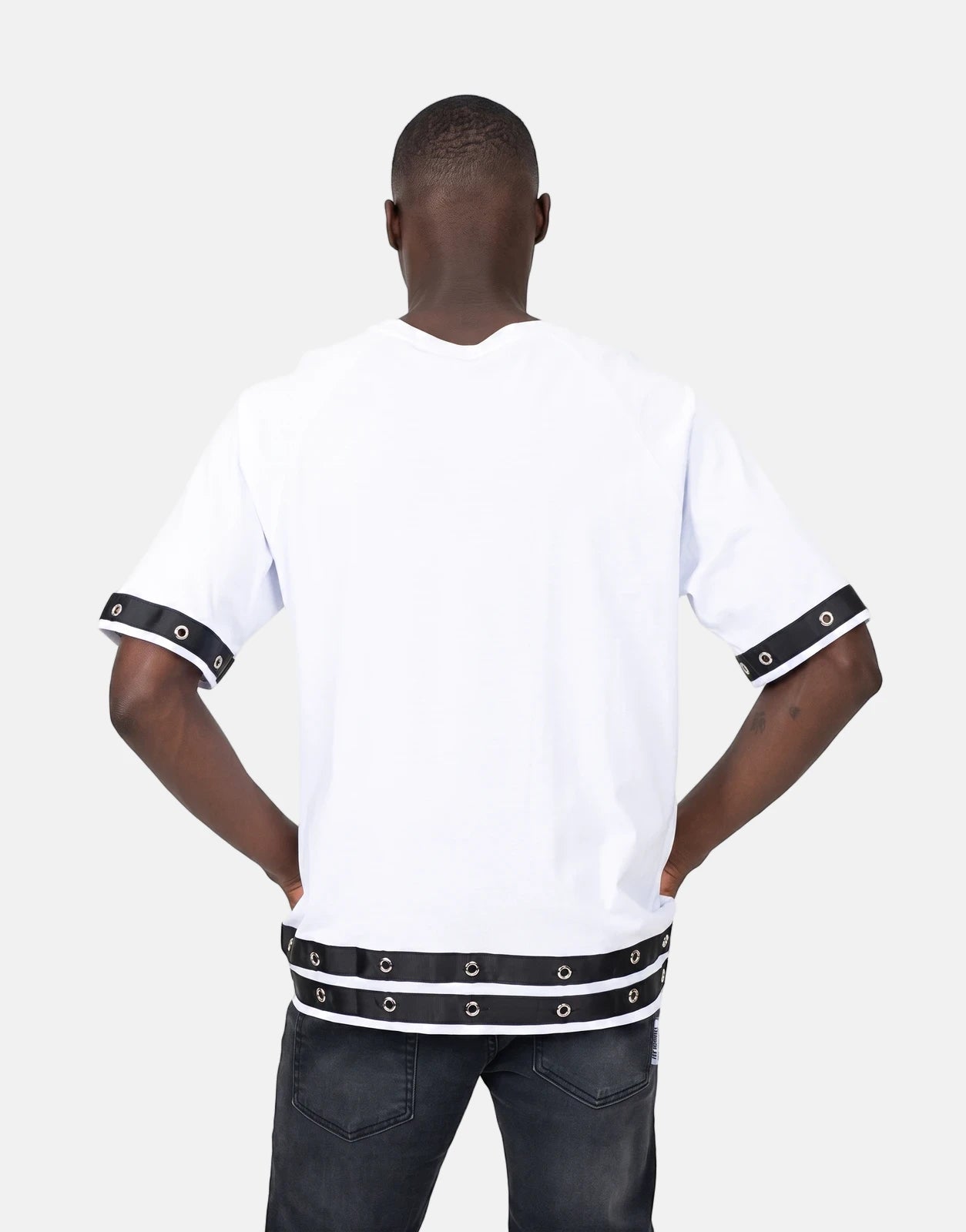 Les Hommes Denim Insert White T-Shirt worn by a man from the back, featuring black eyelet bands on sleeves and hem.