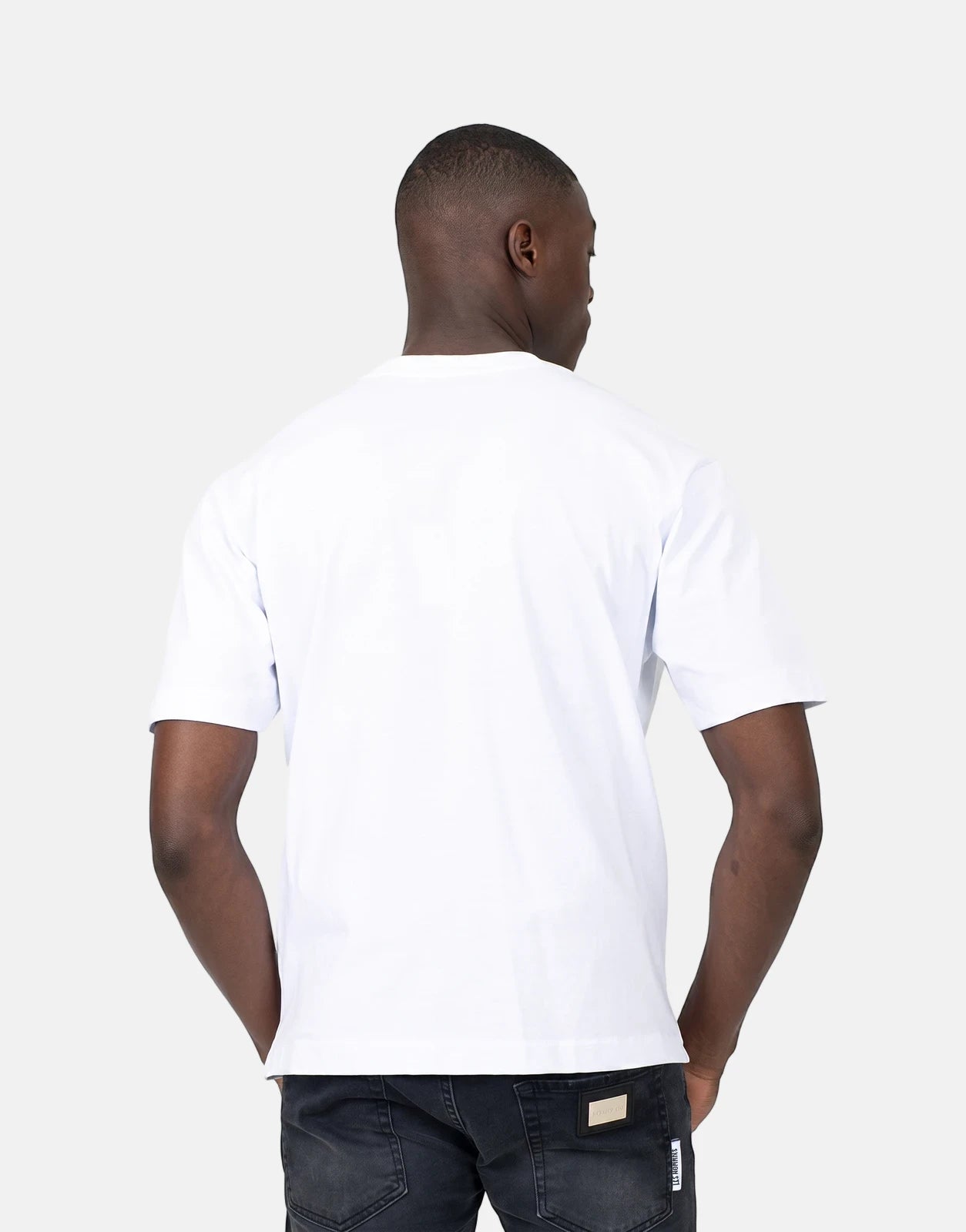 Les Hommes Dragonfly White T-Shirt on a male model, seen from the back wearing black jeans in a studio shot.