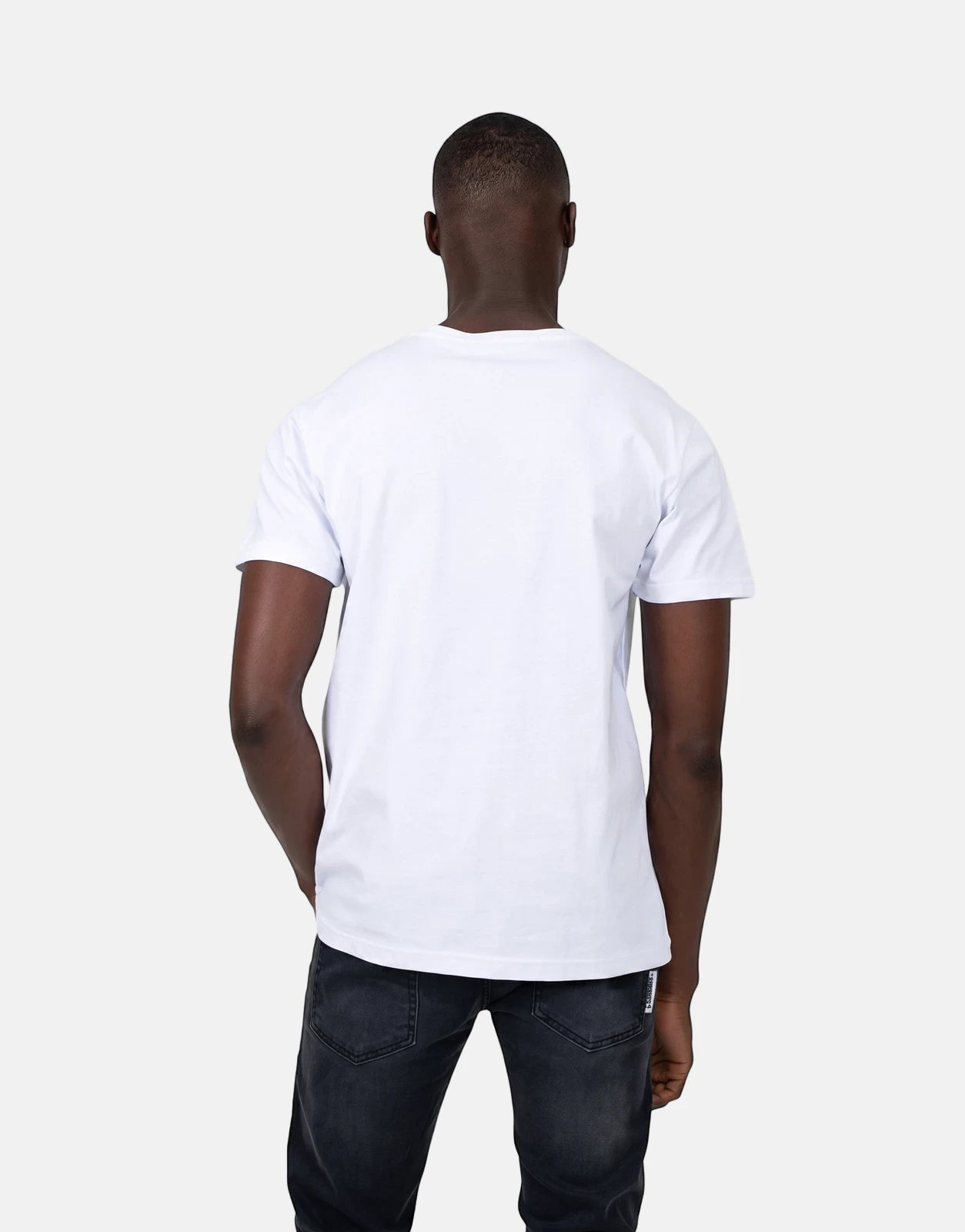 Les Hommes Glitter Logo White T-Shirt on a man, viewed from the back, wearing dark jeans.