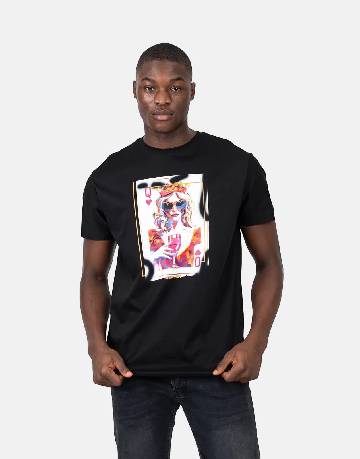 Les Hommes Queen Of Hearts Black T-Shirt on a male model, featuring a vibrant playing card graphic. Front view.